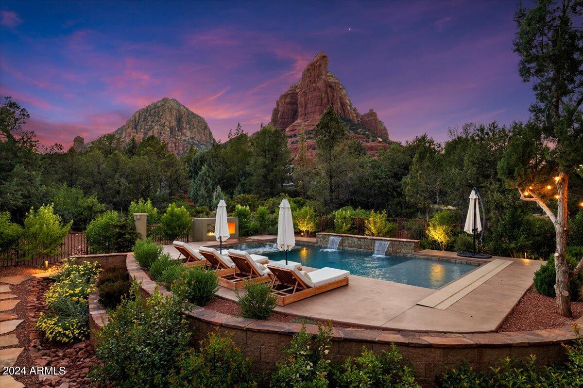 Welcome to Shadow Rock.  Just appraised at 4 million! This beautifully designed custom home is nestled on a large .87 acre corner lot with stunning views of coffee pot rock.  Listed at 6,165 sq ft, including a 1,610 sq ft attached guest house, 5 bedrooms/ 4.5 bathrooms, and a 3 car garage.  As you walk through the foyer you are immediately greeted by soaring ceilings, a timeless interior remodel and large floor to ceiling windows framing the Sedona red rocks.  The main floor is an entertainers dream with an open concept, recently remodeled gourmet chef's kitchen, large kitchen island, and views from every window.  The master bedroom won't disappoint with features like a brand new spa like bathroom, dual vanities, walk in closet, soaking tub and an enormous shower. This split floor plan is extremely functional with the master on the main and the other bedrooms on the floor below. The lower level offers 3 spacious bedrooms with walk in closets, 2 bathrooms, a great room and an office or multi purpose room. The 1610 sq ft permitted guest house is a space that can adapt to your needs.  Whether you have guests visiting, need a separate office, or want to generate passive income as a rental, this guest house can accommodate it all.  Featuring 1 bed/ 1 bath/ plus den, full kitchen, laundry, soaring ceilings, great room, large windows, incredible views and a separate private entrance.   The back yard embraces outdoor luxury with an expansive patio that extends across the back of the home overlooking the newly constructed sparking pool and spa, gas fireplace, green space with artificial turf, mature landscaping and panoramic views of the Sedona red rocks. Located in the highly sought-after Soldier's Pass Corridor you are steps from breathtaking hiking and biking trails, minutes to shopping, dinning and all that Sedona has to offer.   Don't miss this rare opportunity to own a Sedona gem in Shadow Rock Estates.