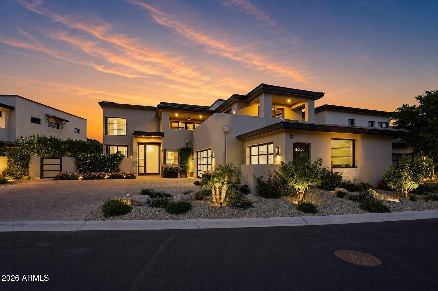 Privately set within the 24/7 guard-gated Village at Mountain Shadows, this exceptional home built by Cullum Homes occupies one of the community's most desirable lots, capturing Mummy and Camelback Mountain views from nearly every room while backing to a tranquil park with a view fence.
As you reach the residence, you're greeted by a striking double-height frosted glass front door and an expansive three-car oversized garage with matching frosted doors, offering an immediate sense of refinement. Inside, the foyer delivers a memorable first impression with inviting textures and colors that set the tone for what's ahead.
The great room is breathtaking, anchored by a dramatic floor-to-ceiling stone gas fireplace and framed by soaring windows that flood the space with natural light while showcasing stunning views of Camelback Mountain. Designed for seamless entertaining, the space flows effortlessly into a sophisticated wet bar complete with a sink, beverage fridge, ice maker, wine fridge, and plenty of seating. From the bar, the dining area is ideally positioned for gatherings, connecting smoothly to the kitchen, which is more than impressive, centered around a substantial island and surrounded by custom cabinetry, featuring a six-burner gas range with griddle, a sleek vent hood, and a double-sized Sub-Zero refrigerator. Also on the main level are a stylish powder room and a refined laundry room with raised washer and dryer and utility sink, both enhanced by designer wallpaper, elegant lighting, and curated finishes. An elevator, adorned with distinctive wallpaper which adds bespoke character. 
The home's thoughtful split floor plan places the primary suite on the main level, which offers a serene retreat, direct backyard access and captivating Mummy Mountain views. The ensuite bath is sophisticated and palatial, featuring a custom walk-in closet, private water closet, freestanding tub, glass surround walk-in shower, dual vanities, and a dedicated makeup vanity, all finished with beautiful tile, lighting, and hardware. 
Ascend via the private elevator or stairs to a comfortable loft welcomes you with an additional wet and an imposing powder room for convenience. Two guest suites, each with their own ensuite baths, offer picturesque views of Mummy Mountain and the verdant park beyond. The office is inspiring, complete with built-ins, warm tones and enchanting views of Camelback Mountain, a direct access to a wraparound deck is perfect for taking in the scenery. 
The backyard is luxuriant, designed for relaxation and entertaining alike, featuring a fountain for ambiance, two custom fireplaces, and ample space for outdoor dining and lounging. A built-in BBQ with a pizza oven completes the setting, all surrounded by vibrant greenery and fragrant landscaping with Mummy Mountain as the backdrop.
Additional upgrades include a sauna, programmable electronic shades throughout, designer wall treatments, upgraded chandeliers and lighting with Lutron lighting system, and a Savant AV package.