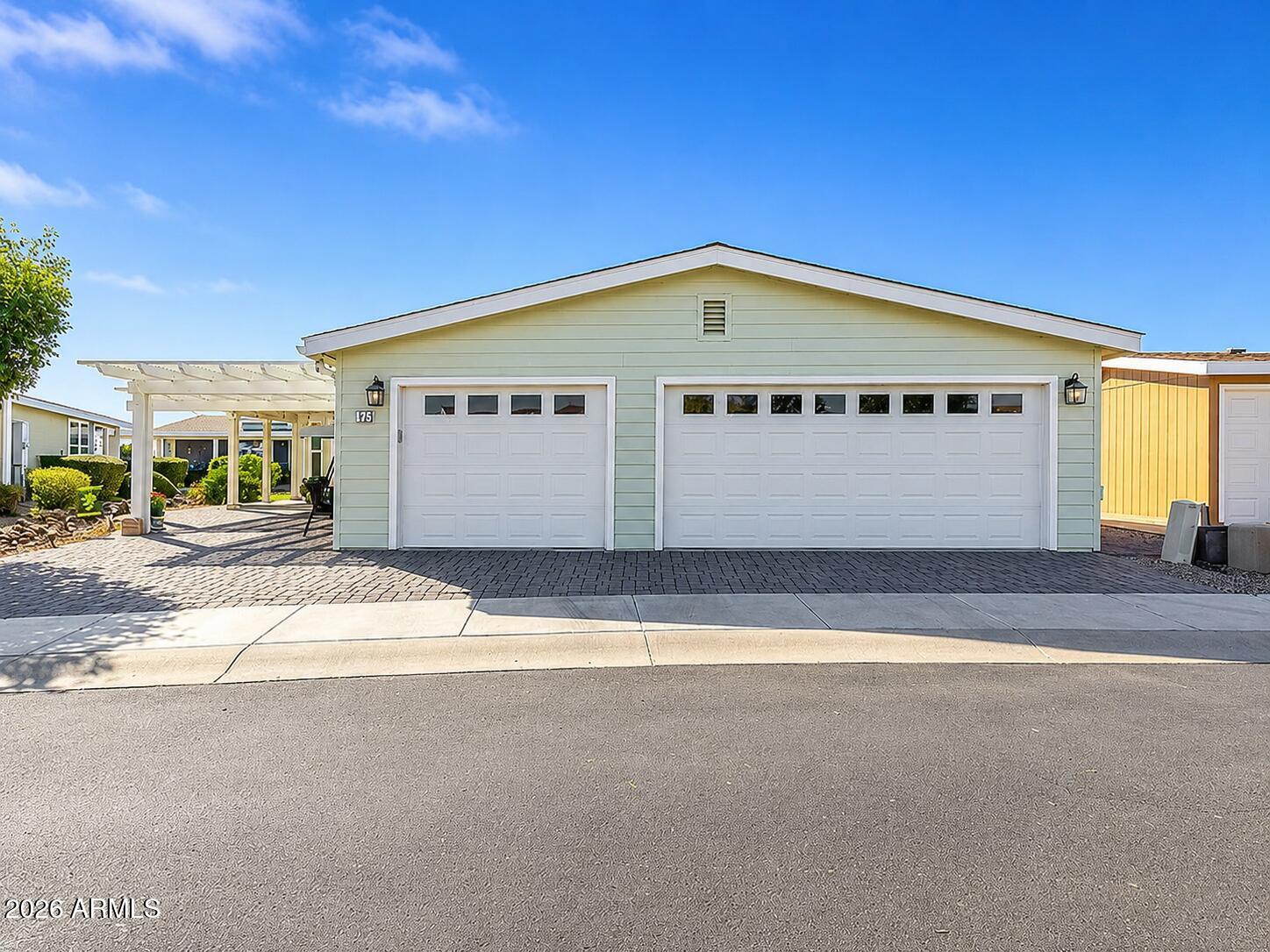 2020 BUILD, 3+ CAR GARAGE, OPEN DEN, COVERED PATIO WITH BBQ. Set in Pueblo El Mirage RV & Golf Resort, this 2 bed, 2 bath home delivers a smart 1,553 sq ft layout with the space buyers keep looking for. The open floor plan uses vaulted ceilings, tile flooring, and natural light to create an easy flow between the main living area, kitchen, and dining space. The kitchen is built for daily use with granite counters, stainless steel appliances, subway tile backsplash, recessed lighting, a prep island, breakfast bar, and generous cabinetry. A flexible open den gives you options for a home office, formal dining area, hobby space, or additional sitting room. The primary suite features double-door entry, a walk-in closet, custom tile, and a glass step-in shower. Storage has been thoughtfully added with overhead cabinets in the hallway and guest room, plus custom closet organization. Outside, a full-length covered patio, built-in BBQ, artificial turf, and inviting front patio make the home feel larger than the square footage suggests. The 3+ car garage is a major advantage and difficult to find at this price point. Pueblo El Mirage offers resort-style amenities including golf, pool, pickleball, tennis, clubhouse, fitness center, dining, and more.