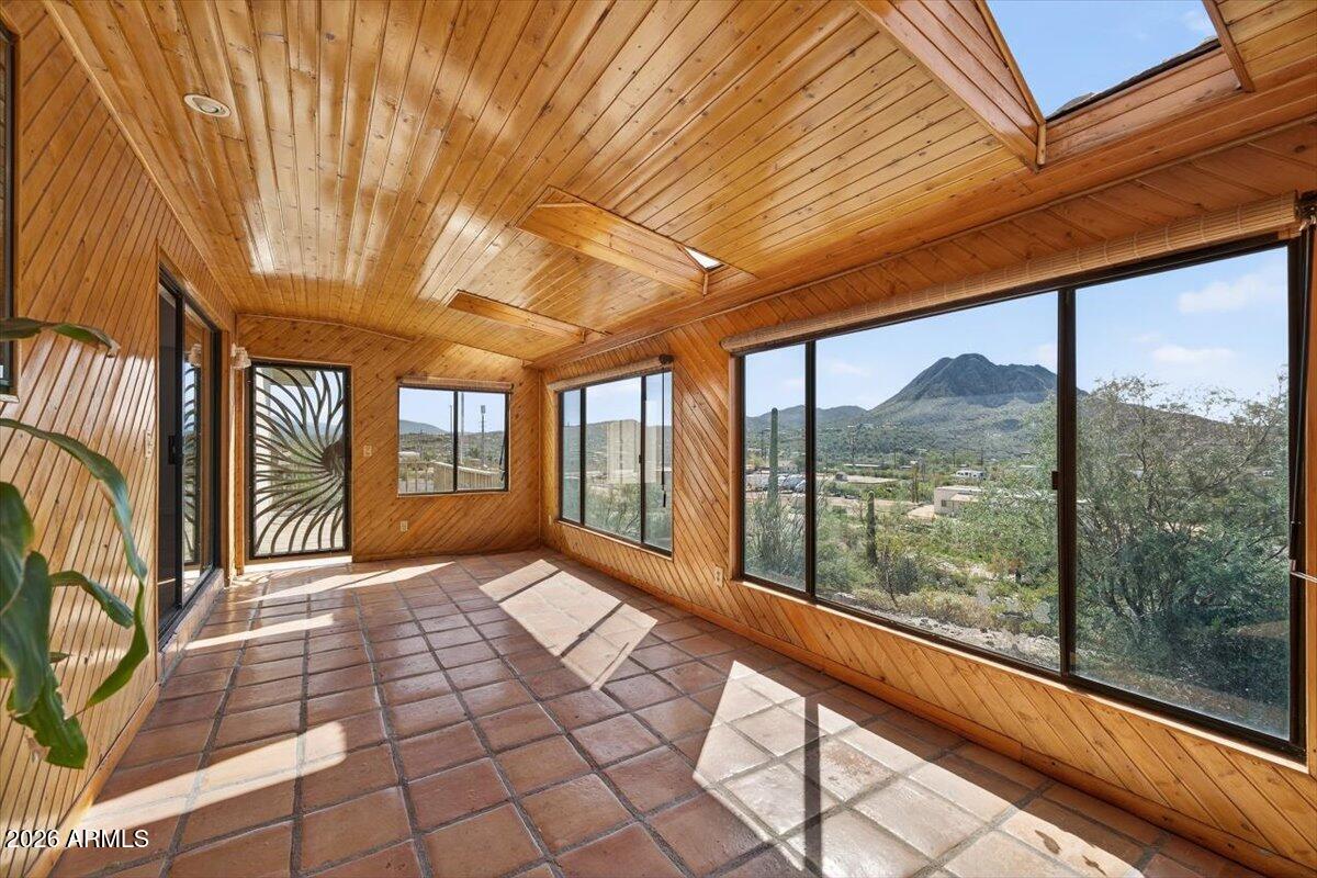 Highly flexible property featuring two self-contained 3-bedroom, 2-bath residences connected by a shared laundry room and an extraordinary Arizona Room with mountain views, skylights, and tongue-and-groove wood ceilings. Ideal for multi-gen living, extended family, caregiver housing, shared ownership, home- business, employee housing, or other flexible residential needs.
The East Residence features a bigger kitchen, spacious family room, office/flex space, wraparound view deck, and access to approx. 500 square feet of finished recreation and flex space below. The West Residence offers a complete second living quarters with its own kitchen, living room, 3-bedrooms & 2-baths.An opportunity for those seeking flexibility, privacy & room for multi-family households under one roof!