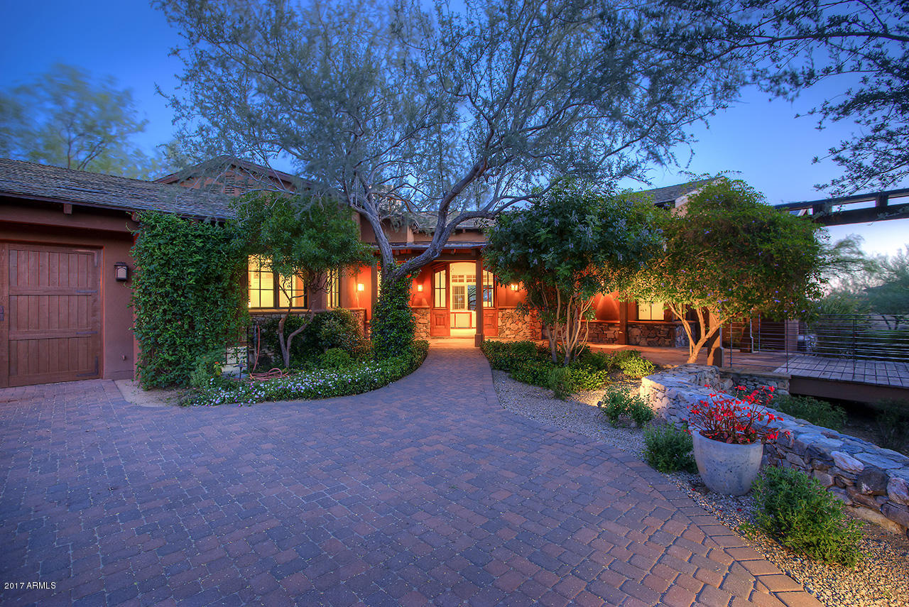 This DC Ranch custom is uniquely situated on the 17th fairway capturing sweeping views of the McDowell mountains, serene golf course and cascading city lights.
Built by Fisher Homes and remodeled by Eric Linthicum in 2015, this sophisticated prairie ranch offers a well-planned design with desirable four car garage and regal interiors throughout.  Striking Brazilian wood flooring, temperature controlled glass wine wall, impressive grand stone fireplace walls, five wood burning/gas fireplaces and timeless Venetian plaster set the stage of this chic artistic home.  Luxurious kitchen with oversized marble top island features Viking/Double Sub-Zero and an substantial butler pantry/prep/utility room.  Resort style master suite includes alluring marble finishes, (click ''more'' to continue) a Margaux burnished silver cast iron tub and hardware from Waterworks, and  "her" stunning private wardrobe room and water closet.  Spacious 800 sq ft detached three-room guest casita comfortably welcomes guests.  Private outdoor living with ample covered patios (9,771 sq ft under roof), negative edge pool and spa, putting green and BBQ.  Secret garden with gorgeous lilly-padded koi pond.  Distinctive refinement at its best.