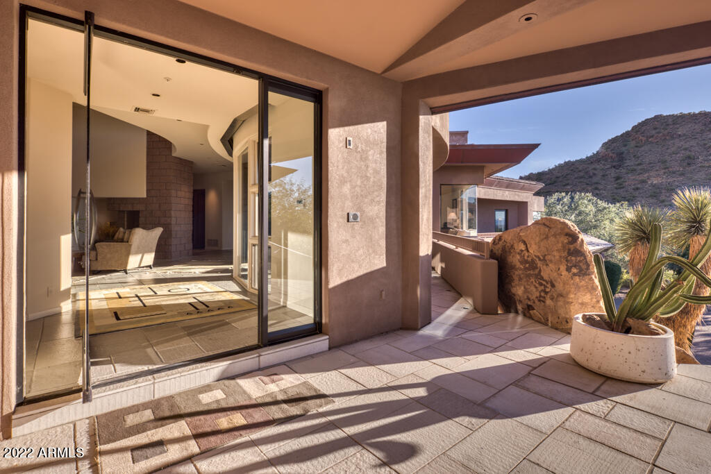 STUNNING SOFT CONTEMPORARY RESIDENCE, LOCATED ON THE STREET OF DREAMS IN ESTANCIA!  THIS ESTATE HOME IS SITED ON ONE OF THE LARGEST PARCELS (NEARLY 1.5 ACRES) IN THE RENOWNED GUARD-GATED COMMUNITY, HOME TO THE TOM FAZIO-DESIGNED ESTANCIA CLUB.  THE BUYER PREMIUM FOR THIS PRIVATE LOCALE IS EVIDENCED BY THE BREATHTAKING SUNSET AND CITY LIGHT/MOUNTAIN VIEWS.  THE HOME IS IDEALLY SET BACK ON THE BUILDING PAD FOR MAXIMIZING PRIVACY AND 40 MILE VIEWS.  THE ARCHITECTURE ALLOWS FOR GORGEOUS NATURAL LIGHT THROUGHOUT AND FEATURES EXTENSIVE USE OF BEAUTIFUL CHERRY WOOD, COPPER DETAILING AND IVORY TUMBLED TRAVERTINE  PLUS SOLID SLUMP BLOCK CONSTRUCTION.  KITCHEN FEATURES INCLUDE VIKING, SUBZERO AND GROHE APPLIANCES. THE CURRENT FLOOR PLAN HAS AN EXPANSIVE PRIMARY SUITE, TWO PRIVATE GUEST SUITES, AND OPEN CHEF'S KITCHEN TO FAMILY ROOM PLUS ELEGANT ENTERTAINING AND DINING ROOMS.  A LOWER LEVEL ENTERTAINMENT ROOM PROVIDES A GREAT CINEMA AND GAMING ZONE OR COULD EASILY BE  CONVERTED TO A FOURTH BEDROOM .  ADDITIONALLY, THERE IS ROOM IN THE BUILDING ENVELOP TO ADD A SEPARATE CASITA.  A DEDICATED COMMERCIAL-GRADE ELEVATOR PROVIDES ALTERNATIVE ACCESS BETWEEN THE LOWER LEVEL AND MAIN LEVEL OF THIS HOME. THE BACKYARD PATIO AND POOL/SPA AREA IS COMPLETELY PRIVATE AS IT ABUTS NAOS PINNACLE PEAK LAND.  ENJOY STUNNING ARIZONA SUNSETS AND SEAMLESS INDOOR TO OUTDOOR ARIZONA LIVING AT ITS FINEST!