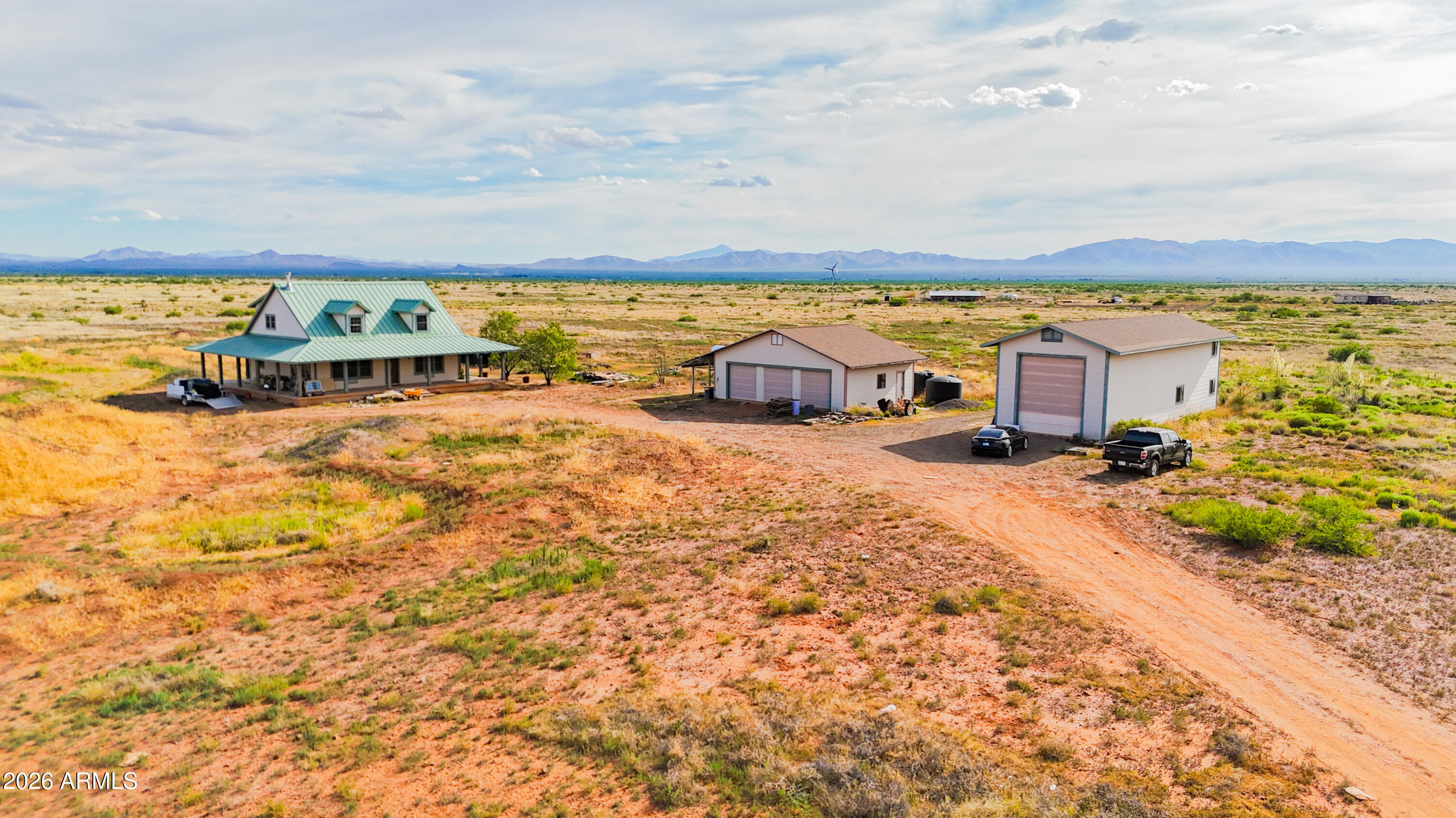 Located in scenic McNeal, this unique off-grid retreat sits on 80 acres across two parcels with approximately 40 fenced acres. The well-built 2-story home offers approx. 1,700 sq ft, a metal roof, and a large wrap-around porch with stunning mountain and desert views. Powered by solar with a private well, this property is ideal for homesteading, ranching, or self-sufficient living. Additional improvements include a detached 3-car garage and a large RV garage/barn with plenty of storage and workspace. The home is functional and well constructed with some cosmetic finishing touches still needed, offering the opportunity to customize to your taste. Many of the materials needed to complete the project are onsite.(Includes parcel 405-37-065)