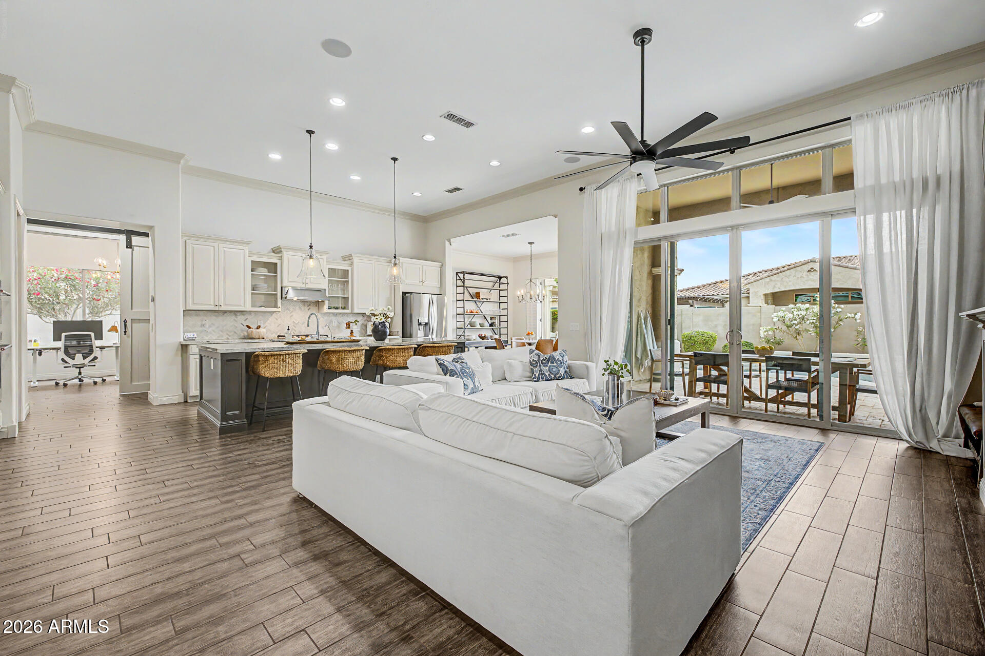 Set in the heart of Gilbert, this exceptional single-story residence blends refined design, upscale finishes, and resort-inspired outdoor living. A charming private courtyard creates a welcoming first impression, leading into a home filled with natural light, elegant design elements that enhance both style and functionality, and effortless indoor-outdoor flow. Inside, the home features a spacious open-concept layout thoughtfully designed for both comfortable daily living and sophisticated entertaining. The expansive floorplan includes 4 bedrooms, 3 bathrooms, private office, formal dining, casual breakfast nook, and a versatile flex room ideal for a media lounge, teen room, or secondary living space. The heart of the home is a gourmet chef's kitchen designed to impress, featuring an... oversized island, built-in stainless-steel appliances, sleek designer backsplash, and extensive cabinetry offering both beauty and abundant storage. The expansive island serves as a natural gathering space--perfect for hosting guests or enjoying casual meals.

Privately positioned for maximum comfort, the split primary suite offers a luxurious retreat with generous proportions and a spa-inspired en-suite featuring dual vanities, soaking tub, separate glass-enclosed shower, and the rare convenience of two spacious walk-in closets. A separate guest suite offers ideal privacy for visitors, while the additional bedrooms are all generously sized, providing comfort and flexibility for family or guests.

Step outside to a beautifully designed backyard oasis with sparkling pool and spa, shaded pergola, herb garden, and citrus trees, creating a private setting perfect for relaxing afternoons or evening gatherings under the desert sky.

The third-car garage has been thoughtfully converted into a fully equipped home gym, offering a dedicated space for wellness and fitness while still maintaining excellent storage options.

Located within the highly desirable Bridges at Gilbert, residents enjoy a lifestyle that feels more like a private resort than a traditional neighborhood. Community amenities include scenic catch-and-release lakes, cascading waterfalls, expansive greenbelts, playgrounds, splash pads, sport courts, and miles of walking and biking paths designed to encourage an active and connected lifestyle. The community sits just moments from Gilbert Regional Park and is located within the highly regarded Higley Unified School District, known for its A-rated schools.

Combining luxury finishes, a thoughtfully designed floorplan, and an exceptional location, this remarkable home offers an outstanding opportunity to experience the very best of upscale living in one of Gilbert's most sought-after communities.