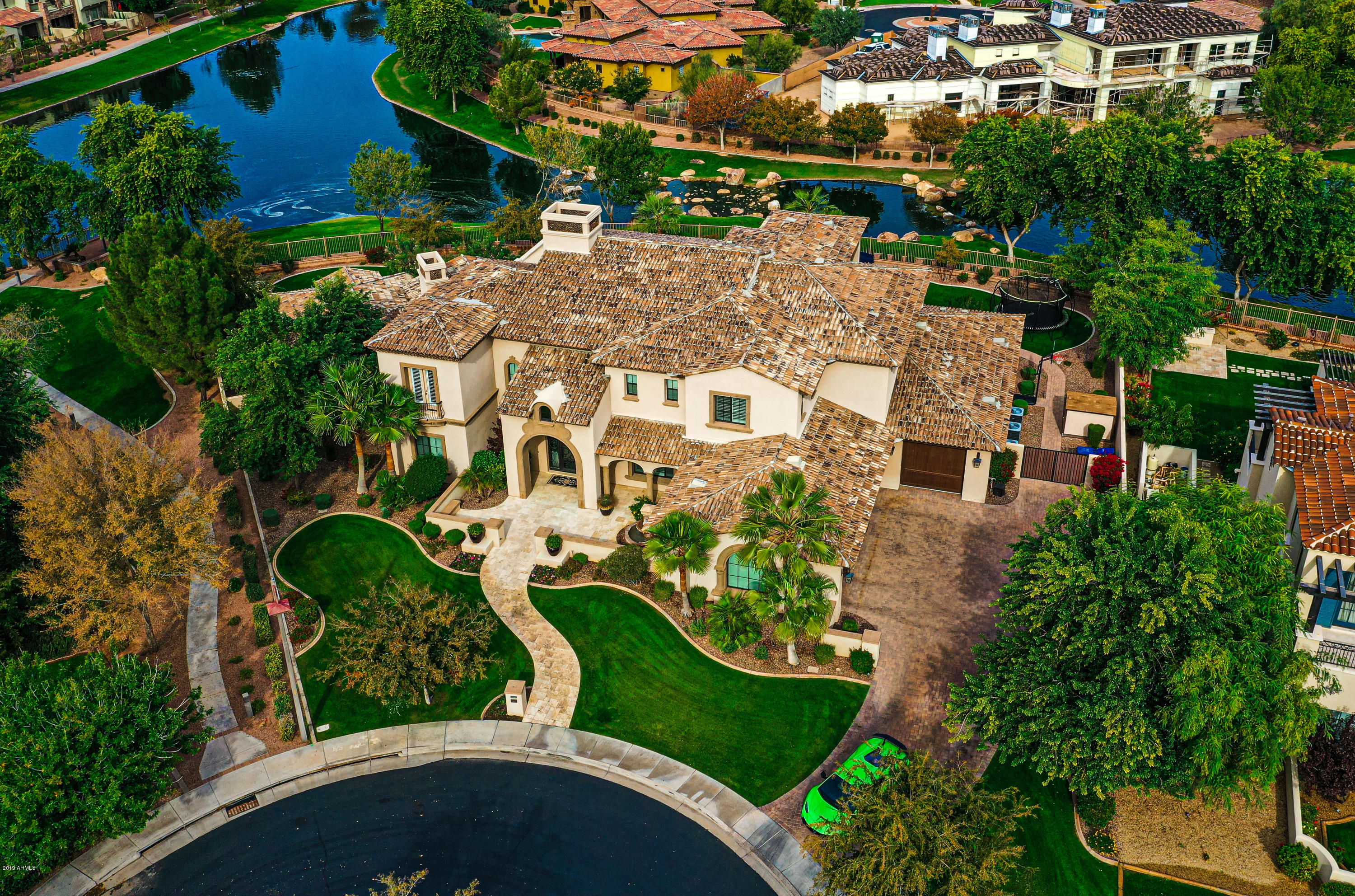 This gorgeous home is located on Chandler's gated island at Fulton Ranch.  Beautiful brick paved driveway to the 5 car garage and RV gates. Enter through the gorgeous ornate front door to a spacious open floor plan, gorgeous stairway, soaring ceilings and a cozy fireplace, complete wet bar, A 1,000 bottle wine cellar, security system with full camera coverage. Gourmet kitchen with granite counters, & breakfast bar. Huge pantry plus a massive indoor storage room by garage. Theater room with a top of the line sound system. Speakers throughout the home! Complete smart home with  nest thermostats. 2 fireplaces. Fabulous outdoor living including a sparkling pool with water features, a spa, and built-in BBQ, WATERFRONT property! more. Close to schools,shopping, golf and easy access to major freeways.