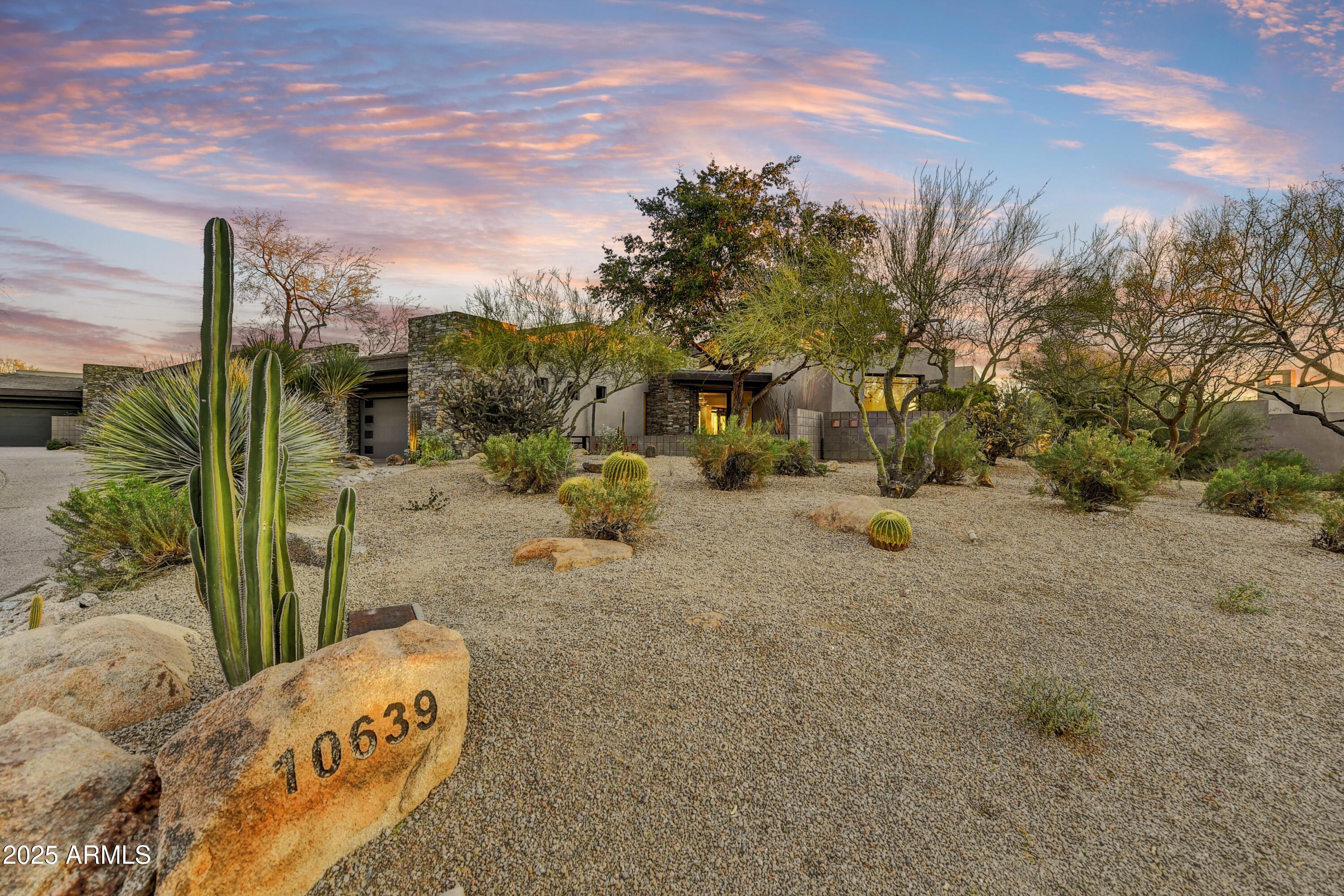 STUNNINGLY REMODELED IN DESERT FAIRWAYS! This reimagined, modern home effortlessly integrates into its newly designed desert-inspired landscape. Nestled on a prime lot with breathtaking south-facing panoramic views, the home offers a private, resort-style outdoor retreat, featuring a shimmering pool and spa, three cascading waterfalls, a cozy gas fireplace, and elegant travertine tile. With 3 bedrooms and 3.5 bathrooms, this home is designed without interior steps, showcasing a wealth of luxurious finishes. Enjoy quartzite countertops, custom cabinetry, two beautifully-tiled fireplaces, and rich wood flooring to captivate your attention. The chef's kitchen boasts a top-of-the-line appliance package and wine wall! Additional upgrades include new roofing and HVAC units. A Golf membership is available, and all current furnishings are included with the home!