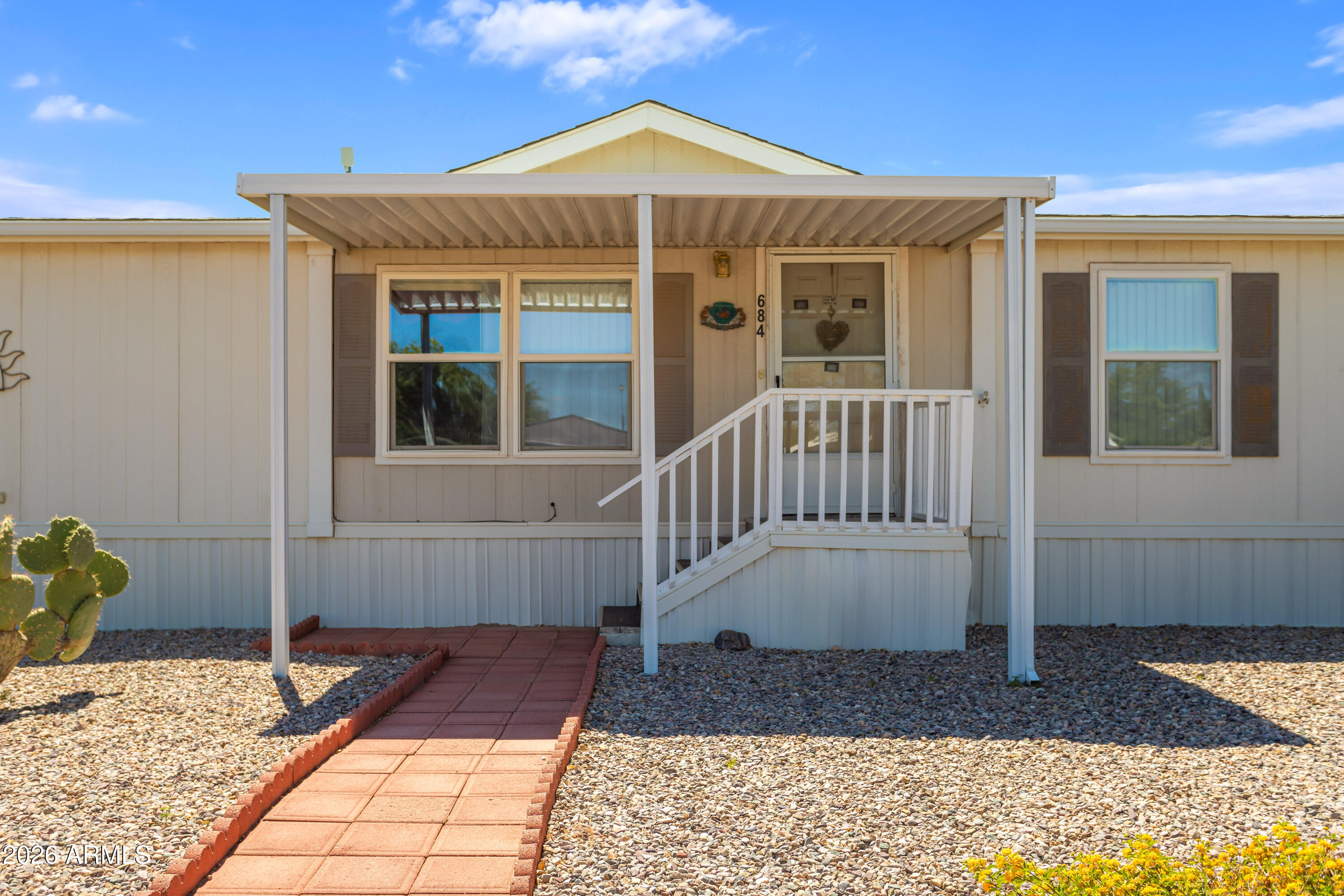 PRICED TO SELL! Affordable manufactured home with a great floorplan in the gated community of Sierra Vista Village, located in one of the most spacious areas of the park. This property features attractive, low-maintenance landscaping, a split floorplan with a large primary suite, 2 guest bedrooms, 2 full bathrooms, spacious living room, kitchen with island, and dining area. Enjoy beautiful mountain views from the large covered back patio overlooking a nicely landscaped walking path. Additional features include a shed with electricity, 2-car carport, and two covered decks. Community amenities include a heated year-round indoor pool & spa, outdoor pool, dog park, pickleball court, bocce ball court, putt-putt golf, and fire pit. Great opportunity... see it while it lasts!