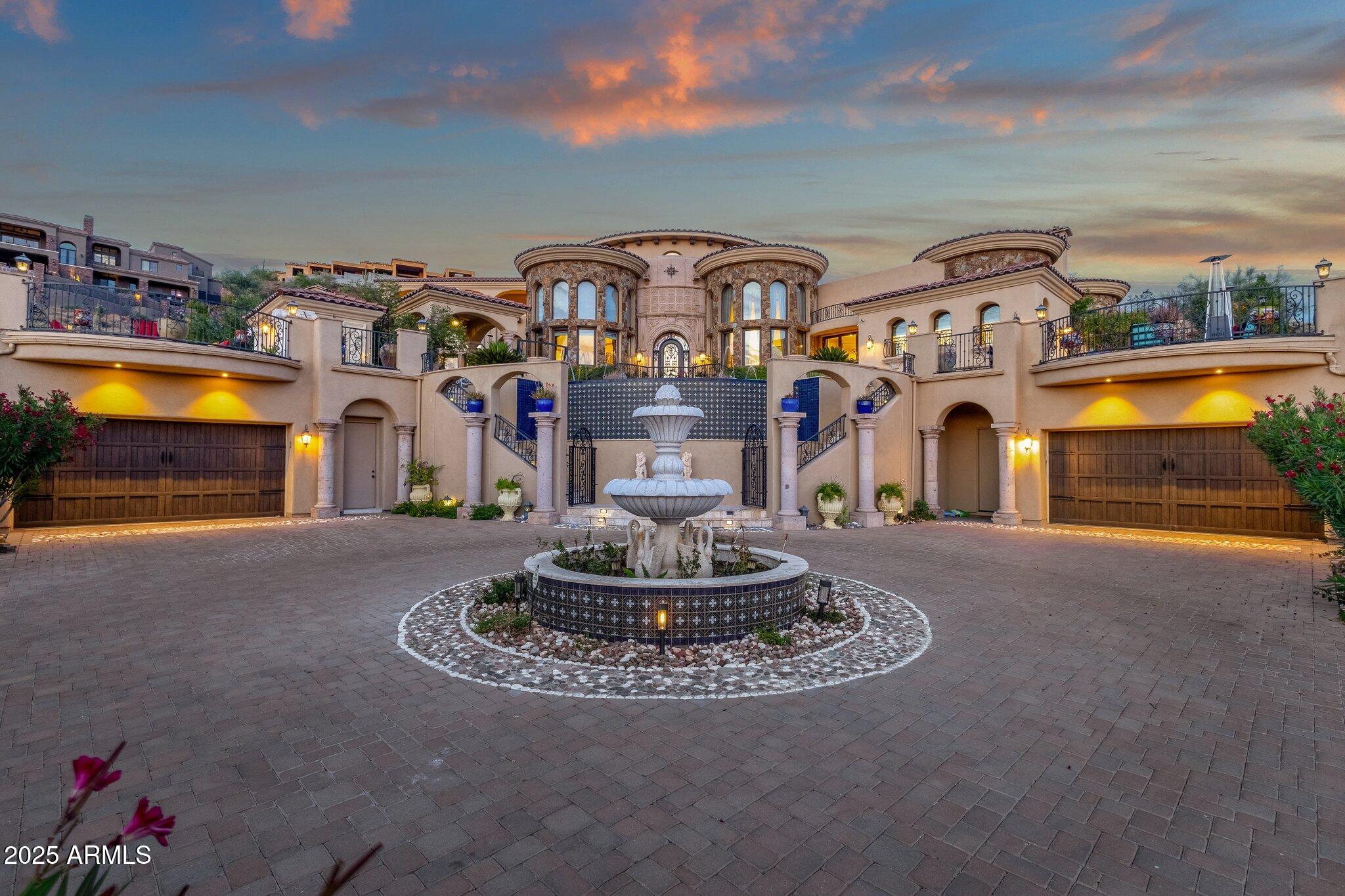 If you're looking for a home that's anything but ordinary, this one is truly unforgettable. With 5 bedrooms, 7 bathrooms, and custom details in every direction, this architectural masterpiece blends luxury with warmth in the most effortless way.

From the moment you step into the grand entry, you're welcomed by soaring vaulted ceilings, alabaster chandeliers, and a stunning floating double staircase trimmed with decorative Talavera tiles. The open floor plan is filled with natural light from large windows that showcase gorgeous views from nearly every room. The kitchen is made for entertainingwith granite countertops, a huge island, custom cabinetry, stainless steel appliances, and accordion doors that open out to the pool and patio. Even the fridge and dual dishwashers are custom paneled to blend seamlessly into the space. And yes, there's a beautiful brick-inlaid vaulted ceiling that gives the kitchen a warm, timeless feel.

Each bedroom offers an en-suite bath and ceiling fan, with the master retreat boasting its own cozy sitting area, walk-in closets, onyx sinks, marble floors, and doors that open out to a peaceful rose garden. There's also a separate junior master suite with its own private outdoor fireplace access.

Need more space? Enjoy a custom home office, a spacious upstairs media room with a pool table, and two laundry rooms for added convenience. Elegant lightingfrom Murano glass to Tiffany lampsadds personality throughout.

Outside, you'll find lush landscaping, a negative-edge pool and spa, multiple seating areas, a ramada, and carved Canterra stone details throughout. A fenced yard makes it pet-friendly, and between the attached garage with elevator and detached garages, there's plenty of room for all your toys.

Every inch of this home offers a unique, handcrafted touchfrom stonework and wood finishes to ceilings that range from vaulted to barrelled. It's a one-of-a-kind sanctuary, ready to wow you at every turn.
