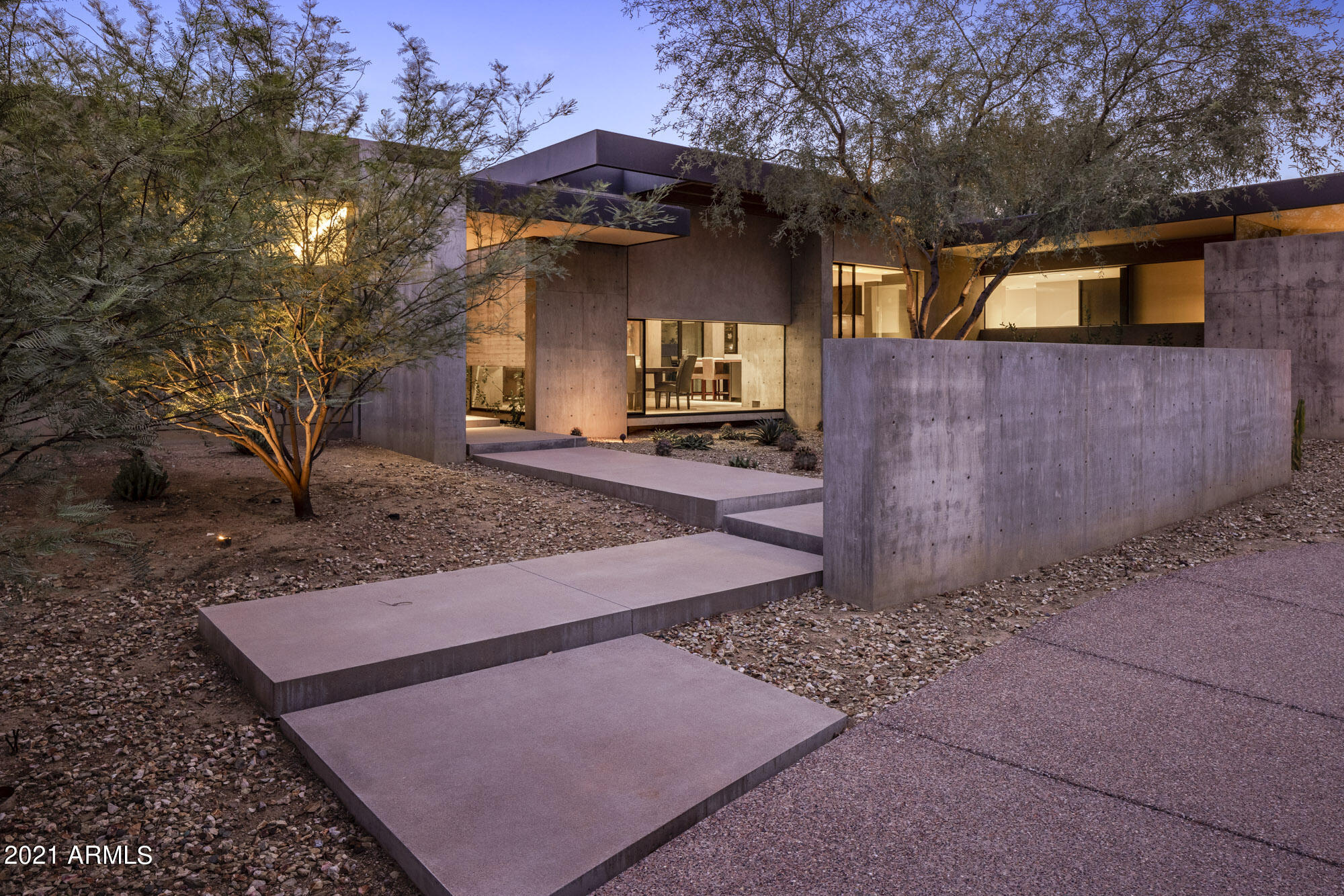 The clean lines of this modern Tennen Studio build highlight its precision design.  The organic, indoor-outdoor living experience feels as if you are outside in nature even when inside, enhanced by substantial concrete walls, structural steel and natural light.  Upon arrival you are greeted by an acre lot of environmentally respectful xeriscape which showcases native plants and conserves water.  The interior of the house is warm and welcoming with wood flooring and natural materials.  A spacious guest house does double duty as a family media room and guest lodging.  Two large home offices offer comfortable and private work-from-home spaces.  Indoor and outdoor kitchens and dining provide entertaining options and easy access to the organic kitchen gardens.  The house is... SEE MORE The house is turn-key, whether you leave for a few days or a few months the house and yard are easy care and low maintenance.  

A floor to ceiling front door welcomes you to wood-formed concrete walls and views of the green spaces that surround the house.  The open concept living area is filled with natural light and views of the green spaces surrounding the house.  It includes a massive concrete fireplace, wood ceiling and stacking sliding doors that open to the outdoors and living room patio which has its own exterior fireplace.  A gracious dining area with a suspended live-edge wood buffet is adjacent to the living room and kitchen. The well-appointed kitchen has island seating and a back pantry with a full counter and three wine refrigerators offering storage for more than 400 bottles of wine.  The indoor kitchen opens onto an outdoor kitchen with a wood fired oven, built in Viking grill and spacious outdoor dining area.  An organic kitchen garden with 3 raised beds is right outside the outdoor kitchen area.  

The outdoor spaces gracefully bridge the main home to the guest house and putting green.  The guest house includes a bedroom and bath, a spacious second office and a large living area with a theater size TV and media room.  Kitchen built-ins help provide snacks for movie watchers or visitors.  The meticulous design and systematic build result in the unification of the home with our desert environment and provides a peaceful retreat for owners and guests alike. Come find your Zen at this incredible home!

OTHER REMARKS:
Garage: Hook-up for Electric Car Charger (no charger, just hook up)
Backyard: Putting Green & Raised Garden Beds
Fireplaces: Living Room, Patio & Outdoor Kitchen under the Pizza Oven
Living Room Sliding Doors: Fleetwood
Lighting: Lutron
Smarthome: Savant
Construction Finish includes poured concrete walls