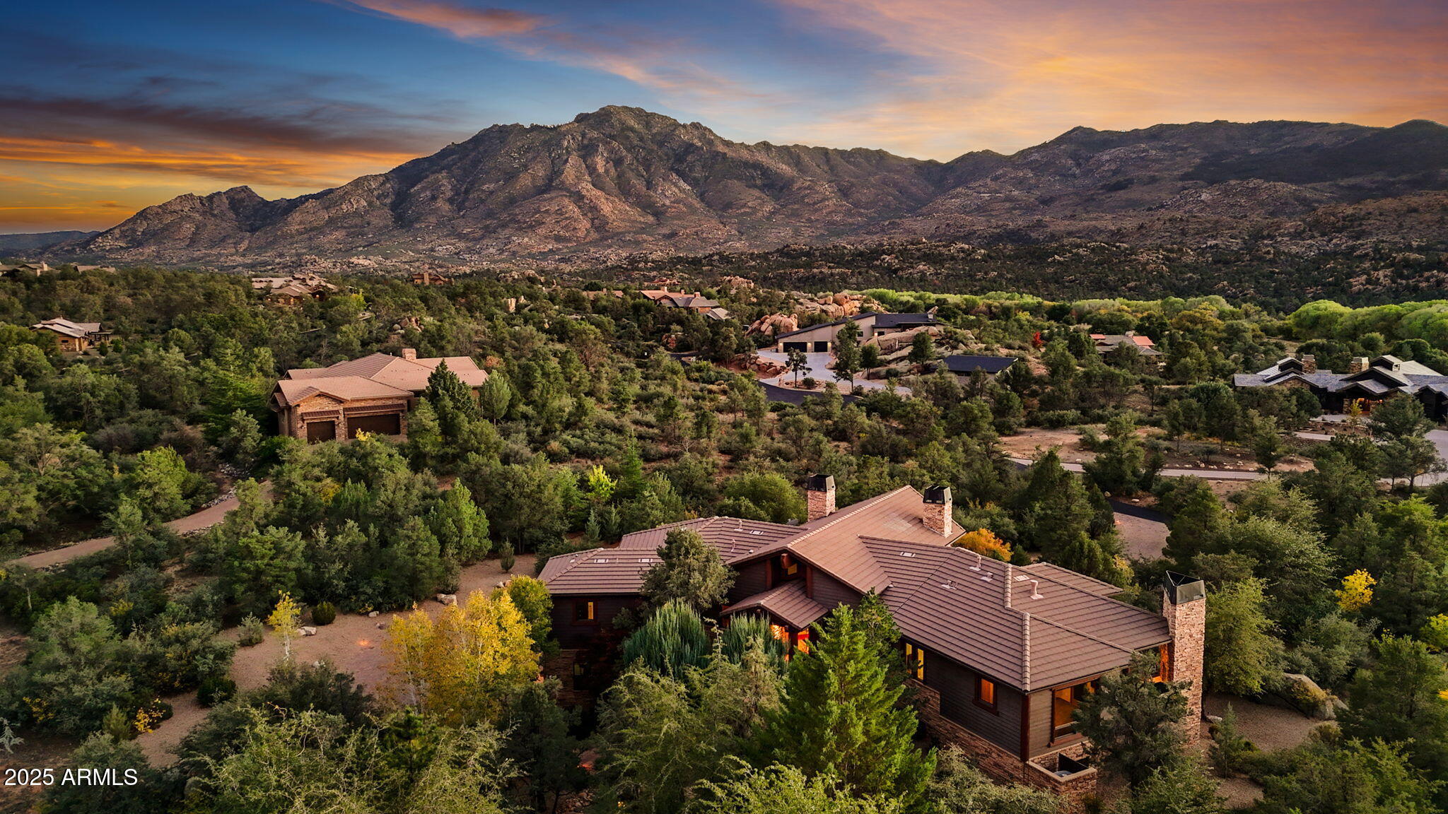 Experience elevated living in this custom 5690 sq ft estate nestled on 3.13 acres. Designed for both luxury and livability, this home offers panoramic views of Granite Mountain through dramatic walls of windows in the living room and master suite. The main level features a spacious master retreat and a private mini-master, complemented by a dedicated TV/Den room , formal dining and breakfast room. The gourmet kitchen boasts high-end appliances, striking blue quartz countertops and backsplash, & custom cabinetry with abundant storage.  Downstairs you will find an additional bedroom, office and space to entertain effortlessly in the expansive game room with a full-size bar or the large media room for movie nights at home.
Outside, enjoy the wrap around deck, waterfall, fireplaces & spa! More...
The outdoor space offers wraparound decks and multiple patios including an elevated hot tub with built-in gas fireplace to create seamless indoor-outdoor living. A show-stopping 70+ foot waterfall feature adds tranquility and visual drama to the landscape.
Additional highlights include a 3-car garage with luxury epoxy flooring, unique architectural details, and access to American Ranch amenities: full equestrian facilities, clubhouse, pool, fitness center, and more.
This is a rare opportunity to own a one-of-a-kind mountain-view masterpiece in one of Prescott's most sought-after communities.