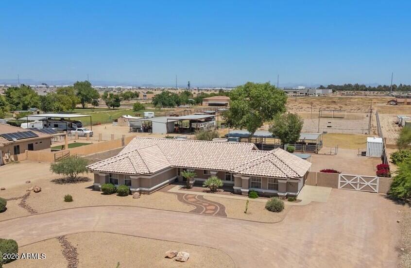 PERFECT HORSE SETUP!  Amazing set up on 2 Acres w/4 covered Stalls, 1700sf Mare motel w/water & electric.  Beautiful 4 bedroom home with new interior paint throughout and recently refinished kitchen cabinets! Great room plan & garage has AC! In addition, there are 2 separate fenced pastures, one with shade plus a separate run to access back pasture. Lighted Arena for dressage or barrel racing between the 2 pastures. plus two water stations. Irrigation is designed so water flows from front pasture through citrus trees into back pasture avoiding arena and the run.  Electric & Water throughout property, even back pasture.  Large Conex for additional storage & yard equipment in barn are incl. East facing backyard for afternoon shade! Huge community of 2 acre horse properties is so impressive!
