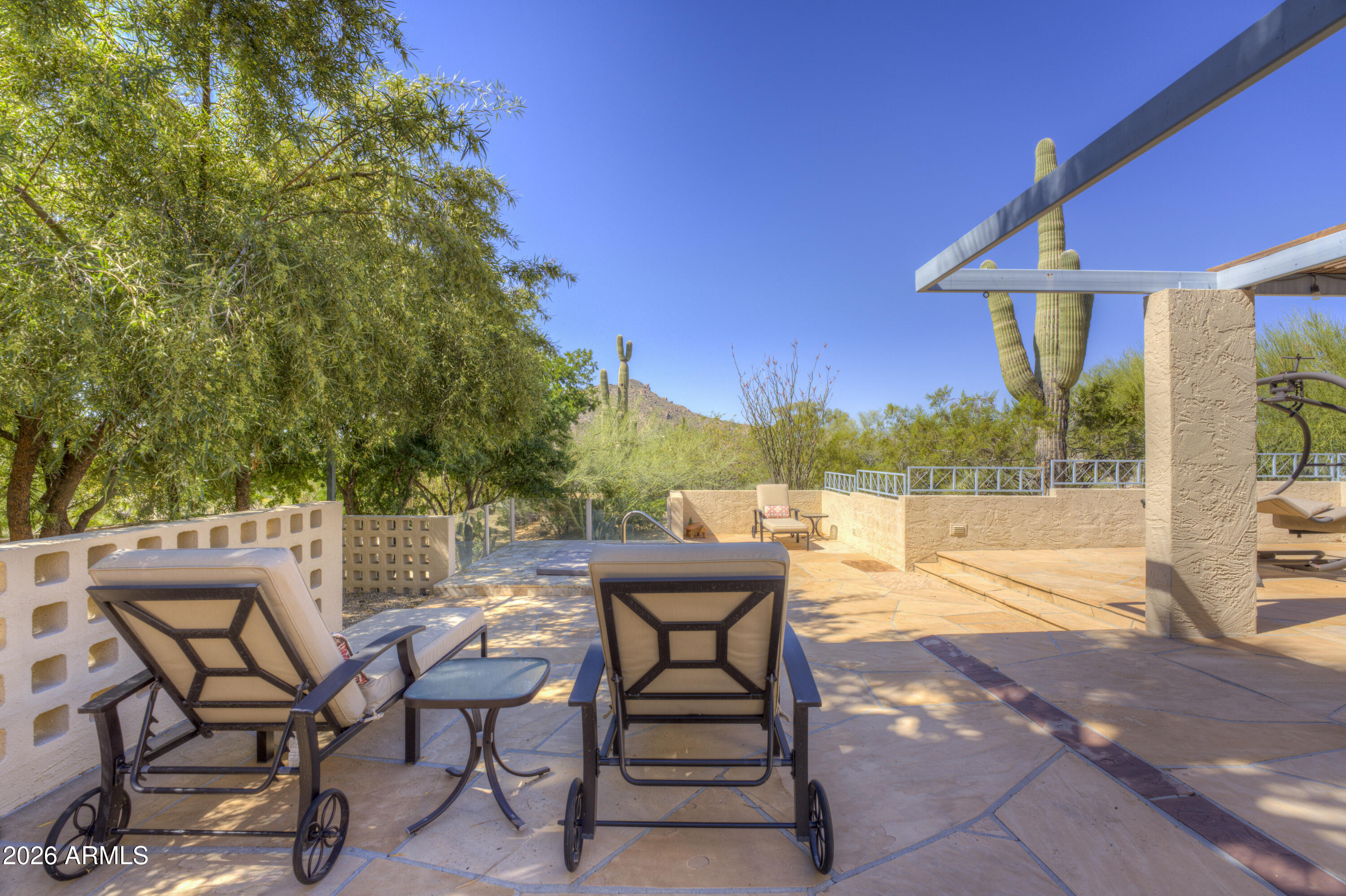 Enduring desert elegance is abundant in this charming Boulders home. Featuring a rare four-bedroom floorplan, this residence offers the flexibility so many buyers seek--perfect for hosting guests, creating a dedicated office, or accommodating multi-generational living without compromise. Warm architectural details set the tone, with soft stucco finishes, subtle vigas.  The thoughtfully designed layout flows effortlessly from the open-concept living spaces to the private bedroom retreats, blending comfort and functionality.  Multiple private patios invite dining al fresco while taking in desert and mountain views.