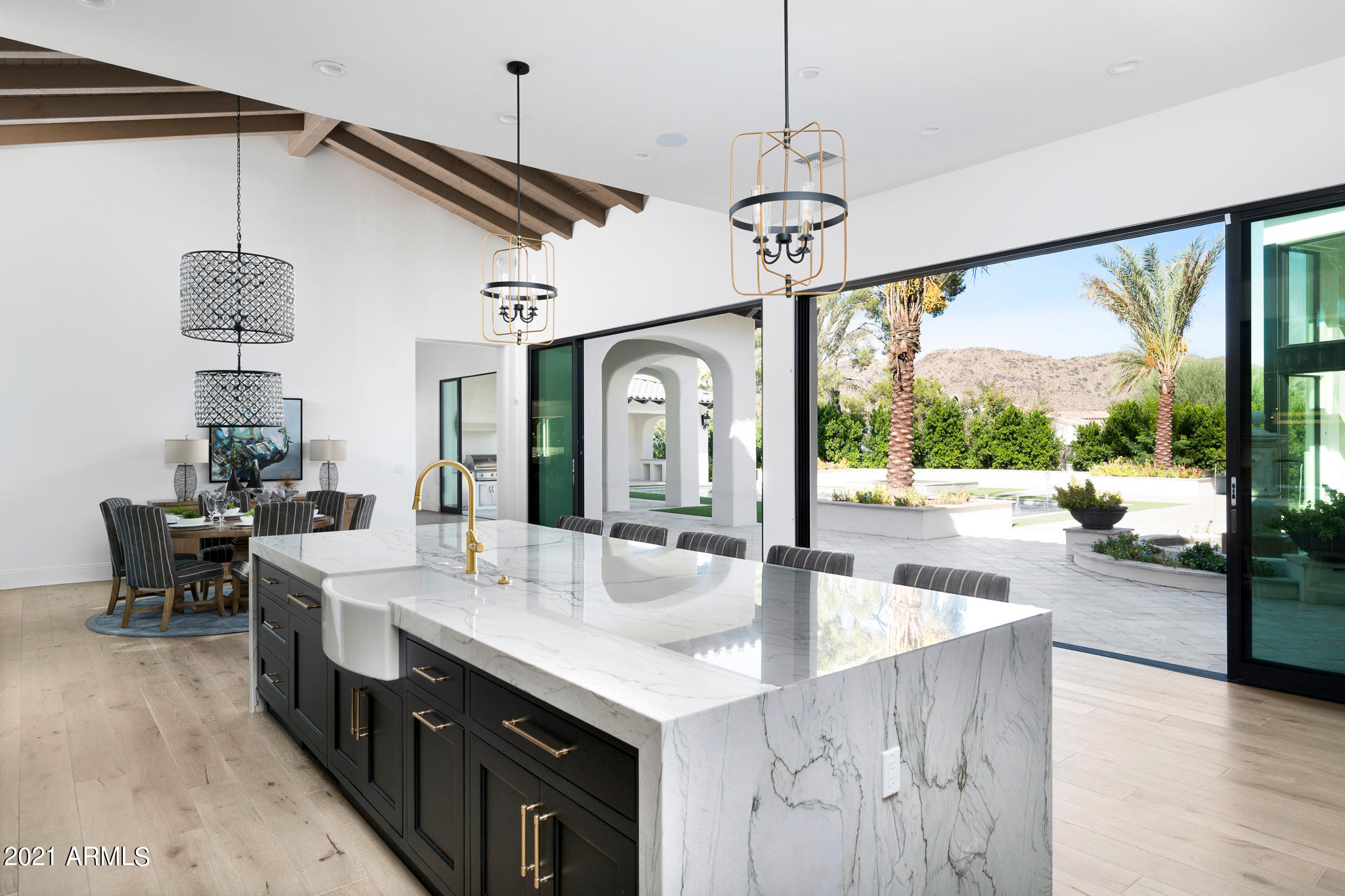 Experience stately living, in Paradise Valley's prestigious Guard Gated neighborhood, Finisterre. This 5 bedroom designer estate offers stunning views of Iconic Camelback and Mummy Mountain. Enter the property's spectacular grounds through Grand Gates to a beautiful motorcourt and opulent foyer. World Class finishes include custom waterfall quartzite and marble counters, black marble slab bar, custom inset cabinetry, climate controlled wine cellar and endless quality throughout. Spacious master bedroom with cozy sitting area, his and her closets, dressing area and exquisite master bath. This timeless estate blends a new generation of design with elegant lines, striking French oak and marble floors, inviting spaces, and 5 retractable glass walls to enjoy Arizona's indoor/outdoor lifestyle.