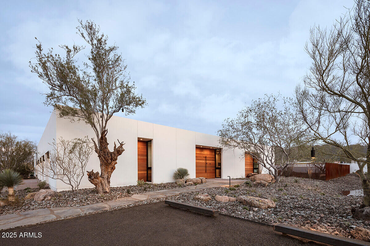 Desert Sanctuary Near Paradise Valley's Finest Amenities.  Completed in January 2020 and celebrated on the cover of Luxe magazine, as well as featured in The Wall Street Journal, Dwell, and other prestigious publications, the ''O-asis'' is a custom-designed masterpiece that redefines luxury living. Nestled at the edge of the Phoenix Mountain Preserve, this exceptional home offers unparalleled seclusion and breathtaking desert views, creating a serene sanctuary enveloped by the natural beauty of the preserve. Yet, its prime location places you just minutes from the upscale amenities of Paradise Valley, the vibrant energy of Scottsdale, and the urban conveniences of downtown Phoenix, including local airports and freeway access. This rare combination of desert solitude and proximity to elite dining, shopping, golf, and cultural attractions makes O-asis a one-of-a-kind haven for a business professional or sophisticated couple seeking an executive lifestyle.

Perched on a nearly 2-acre lot, O-asis is accessed via an extended private driveway, complete with a striking bridge over a desert wash, leading to the home's secluded placement at the end of a close-ended road, more than 250 feet off of 39th Street.  This thoughtful positioning enhances the feeling of living in harmony with the Phoenix Mountain Preserve, where the desert's tranquility and starry nights envelop you. The home's design seamlessly blends modern innovation with its natural surroundings, featuring a material and color palette that echoes the desert landscape, custom-fabricated steel fences, shadow-gapped solid wood door frames, and polished aggregate concrete flooring.

O-asis is a technological marvel, controlled via Apple HomeKit for effortless smart-home functionality. Its eco-conscious design includes a state-of-the-art Tesla solar system and Powerwall batteries, powering the home sustainably, complemented by a Gen 3 Tesla Wall Connector in each of the four garage bays. These forward-thinking features blend seamlessly with luxurious elements, such as top-tier appliances, bespoke cabinetry, and intricate woodwork. The heart of the home is its central living space, where 70 feet of custom glass pocket doors open to an expansive patio and a central atrium, creating a fluid indoor-outdoor experience perfect for entertaining or quiet evenings under the desert sky.

The home is as functional as it is beautiful, with a dedicated yoga room, a spacious home office, and a primary suite featuring a spa-like ensuite and a meticulously crafted walk-in closet. These spaces cater to the discerning owner, offering both productivity and relaxation within the preserve's peaceful embrace.

For visitors or multi-generational living, an attached casita provides a private oasis with a full kitchen, living room, laundry, separate entrance, and secluded patio. Designed to mirror the main home's elegance, the casita ensures comfort and privacy while maintaining a connection to the primary residence, making it ideal for guests or extended family.

O-asis offers a lifestyle of elegance, tranquility, and innovation, where you can savor the solitude of preserve living while being moments from Scottsdale's and Paradise Valley's world-class amenities.