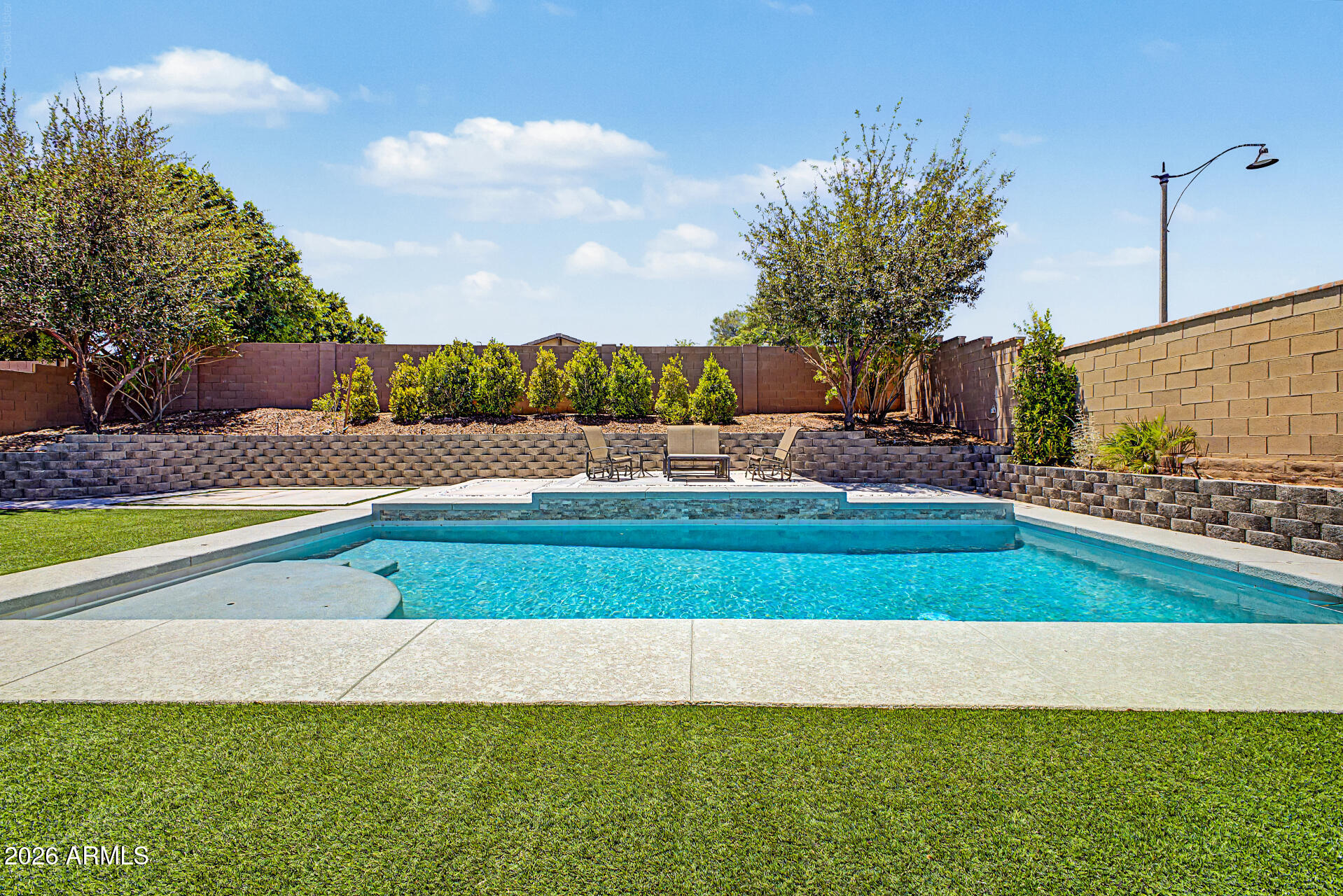 Single story POOL home in the master-planned community of Verrado with a golf cart or third car garage! This home features a sprawling private backyard oasis with a pergola for extra shade & turf - perfect for Arizona living. Home has tile throughout the living area & bathroom, 3 bedrooms plus a den/office.  Kitchen has a walk-in pantry, stainless steel appliances, gas stove & large island. Master suite is off the back of home overlooking pool, with dual vanity sinks, soaking tub & walk-in shower. Verrado offers access to championship golf course, resort-style community pools, splash pad, pickleball court, 78+ parks, hiking trails & fitness center. Verrado offers A-Rated Litchfield School District & close to restaurants & shopping. Verrado welcomes residents with community & holiday events