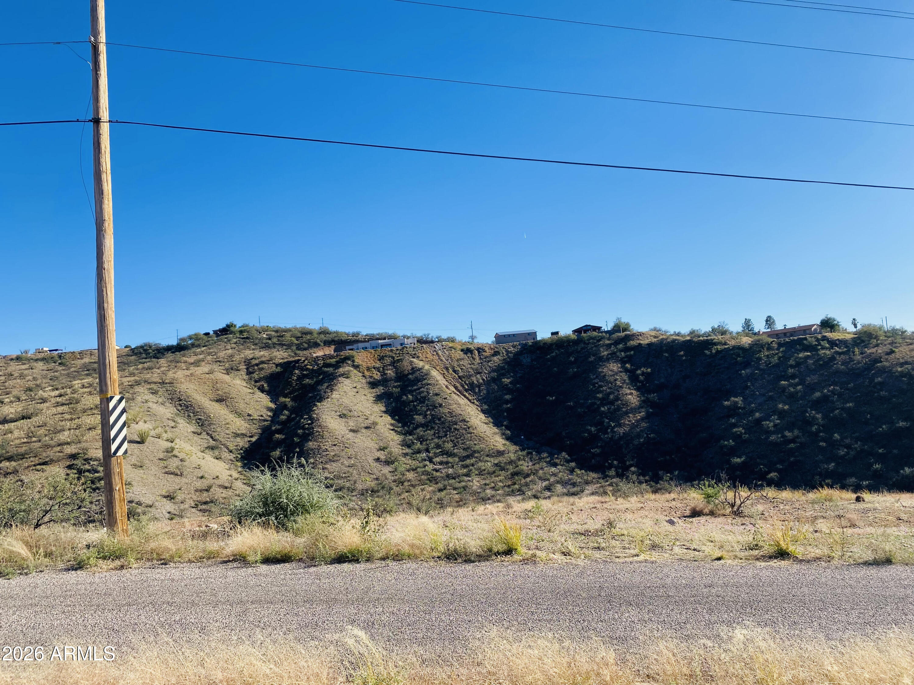 Nestled between two gentle ridgelines, this homesite offers sweeping valley views and a sense of natural privacy. Located just east of two neighboring parcels, the property sits moments from Interstate 19, Exit 17, providing quick access to shopping, schools, and everyday conveniences. Positioned off Rio Rico Drive, the lot features a soft, manageable slope--ideal for building your dream home in a peaceful, picturesque setting.