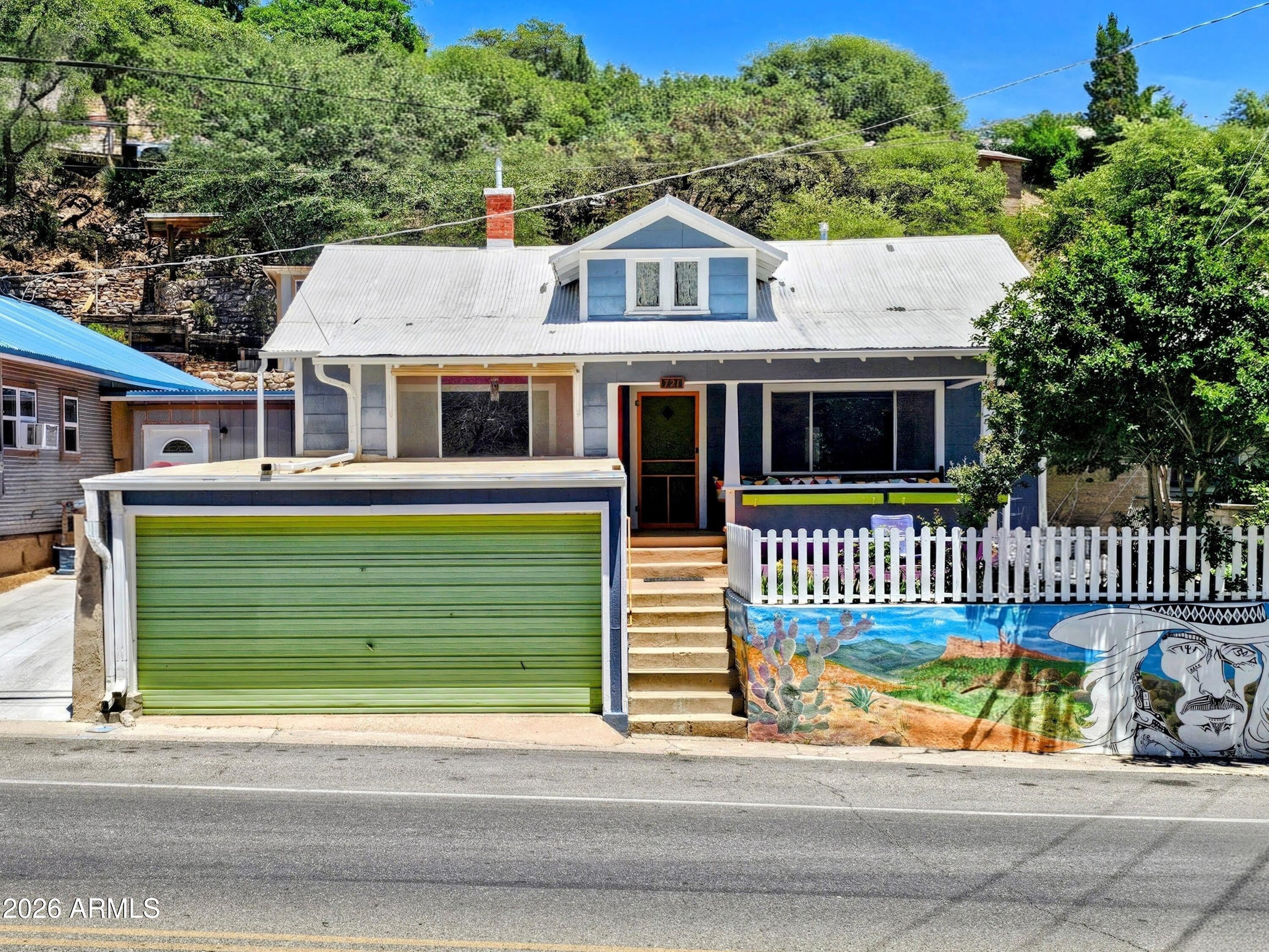 Historic Old Bisbee Bungalow: 1,446 sq. ft.  Two Bedroom/One Bath Craftsman Style Home, Garage and Terraced Back Yard. With Newer Central Heat and AC, Remodeled Kitchen (newer Dishwasher, Stove, Copper Sink, Quartz Countertops, Custom Cabinetry), Automatic Garage Door Opener, and 200 Amp Panel. Spacious Living Room, Formal Dining Room, Classic Front Porch, Office Space, Hallway with Built-Ins, Closets in both Bedrooms (including Walk-In Closet in Primary Bedroom), Original Maple Flooring and Storage Shed. The easily accessible Backyard Space stretches uphill, all the way to Warren Avenue, with Pathways, Hardscape, Xeriscape, Mature Trees, Succulents and Great Mountain Views.