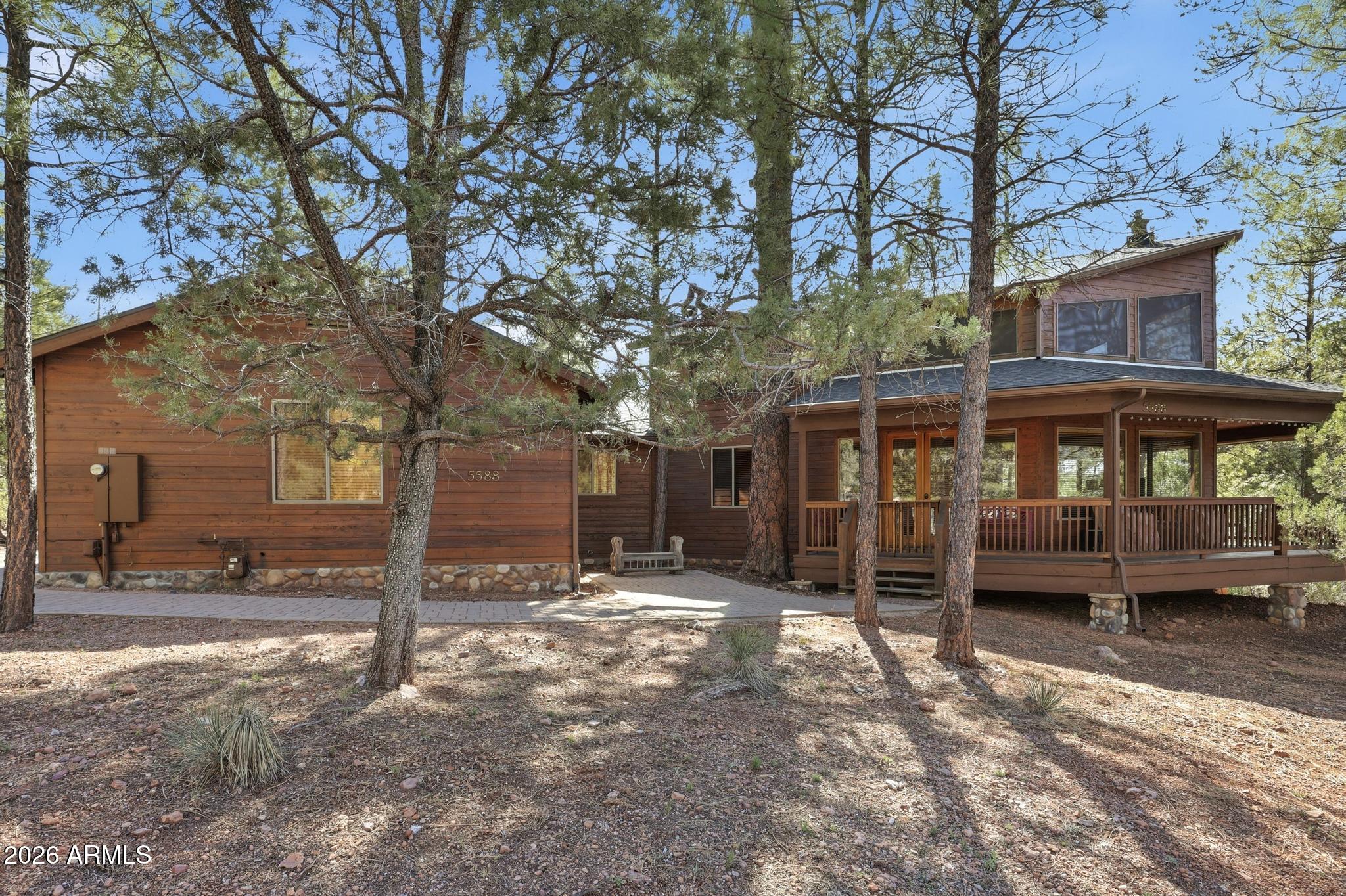 Located on a beautifully treed .33-acre lot in the gated community of Solitude Trails, this wonderful 2,500+ square foot cabin offers the perfect blend of privacy, comfort, and mountain charm. Surrounded by stunning Ponderosa pines, the setting alone makes this property a true escape from the desert heat. Offered completely furnished, this well-maintained and nicely appointed home is truly move-in ready. The wood floors, tongue and groove ceilings and wooden blinds throughout bring a special warmth -- ideal as a summer retreat or full-time mountain residence. All bedrooms are conveniently located on the main floor, including a spacious primary suite featuring separate shower and tub.