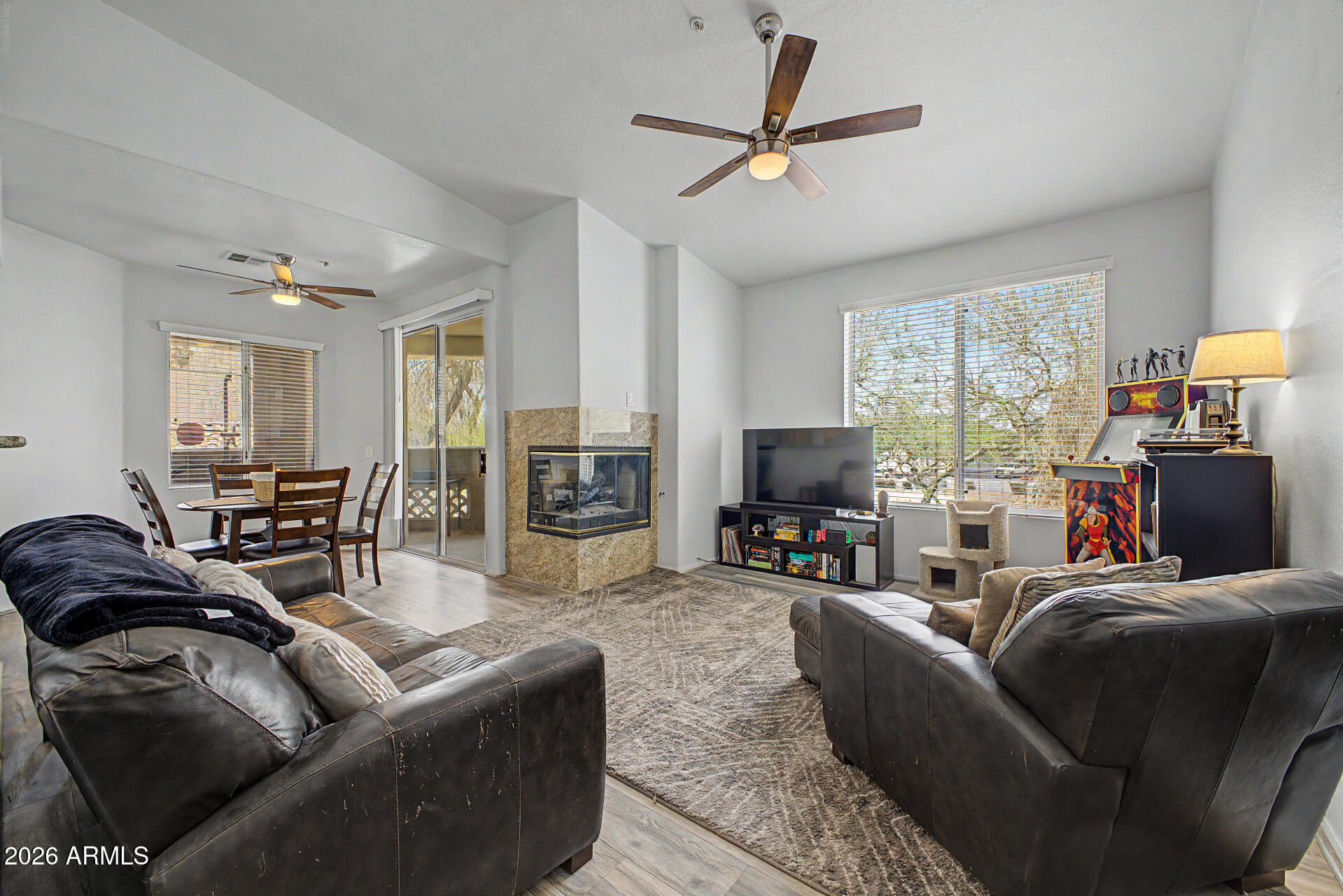 This charming 2 bd, 2 ba second-story unit offers 1,019 sq ft of comfortable living space. Tucked within a cozy gated community offering a perfect blend of comfort and convenience. The open living area features a gas fireplace, luxury vinyl flooring throughout the home, tile flooring in bathrooms, ceiling fans, and an inside laundry for added convenience. The kitchen showcases granite countertops and all appliances are included. Enjoy natural light throughout with sliding glass doors in both the dining area and spacious primary suite, leading to a large wraparound patio perfect for relaxing or entertaining. Community amenities include pools, spas, clubhouse, and fitness center. Conveniently located near shopping, hospitals, and easy access to the I-17 and the 101 freeways.