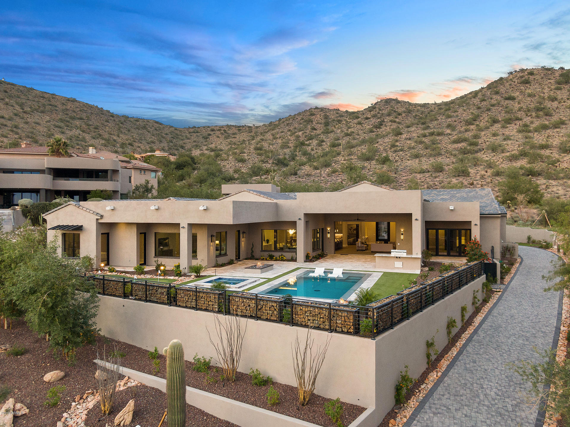 The spectacular views are what will draw you in - the stunning design and finishes are what will inspire you to purchase this gorgeous 2019 new construction in Ancala Country Club. This rare single level, hillside home boasts a breathtaking backyard facing Camelback Mountain and the Valley of the Sun, an attached one bedroom, one bath guest casita with family room & kitchen, dining room with 2 refrigerated wine closets & an over-sized picture window framing the city & mountain views, all en suite bedrooms, wood plank floors, marble floors, custom lighting, automated retracting Pella sliding doors that open to an amazing back yard - complete with putting green, fire features, built-in BBQ/cook area, play pool and heated spa. The paver driveway takes you to the side of the mountain where you enter the home through a custom glass and iron door. Some of the unique features include: 60' Wolf gas range, double SubZero fridge & freezer, warming drawer, double islands, marble counter tops, custom gray-stained cabinets, LED lighting, hand-hewed beamed ceilings, limestone fireplaces, Miele coffee system, floating bathroom vanities with reclaimed wood features, floating LED backlit bathroom mirrors, silver Travertine paver patio, full wood-cased interior Pella windows and doors...and more details than there's room to list. All facts, figures and measurements are approximate, subject to change without notice and not guaranteed by listing agents/broker, builder or seller.