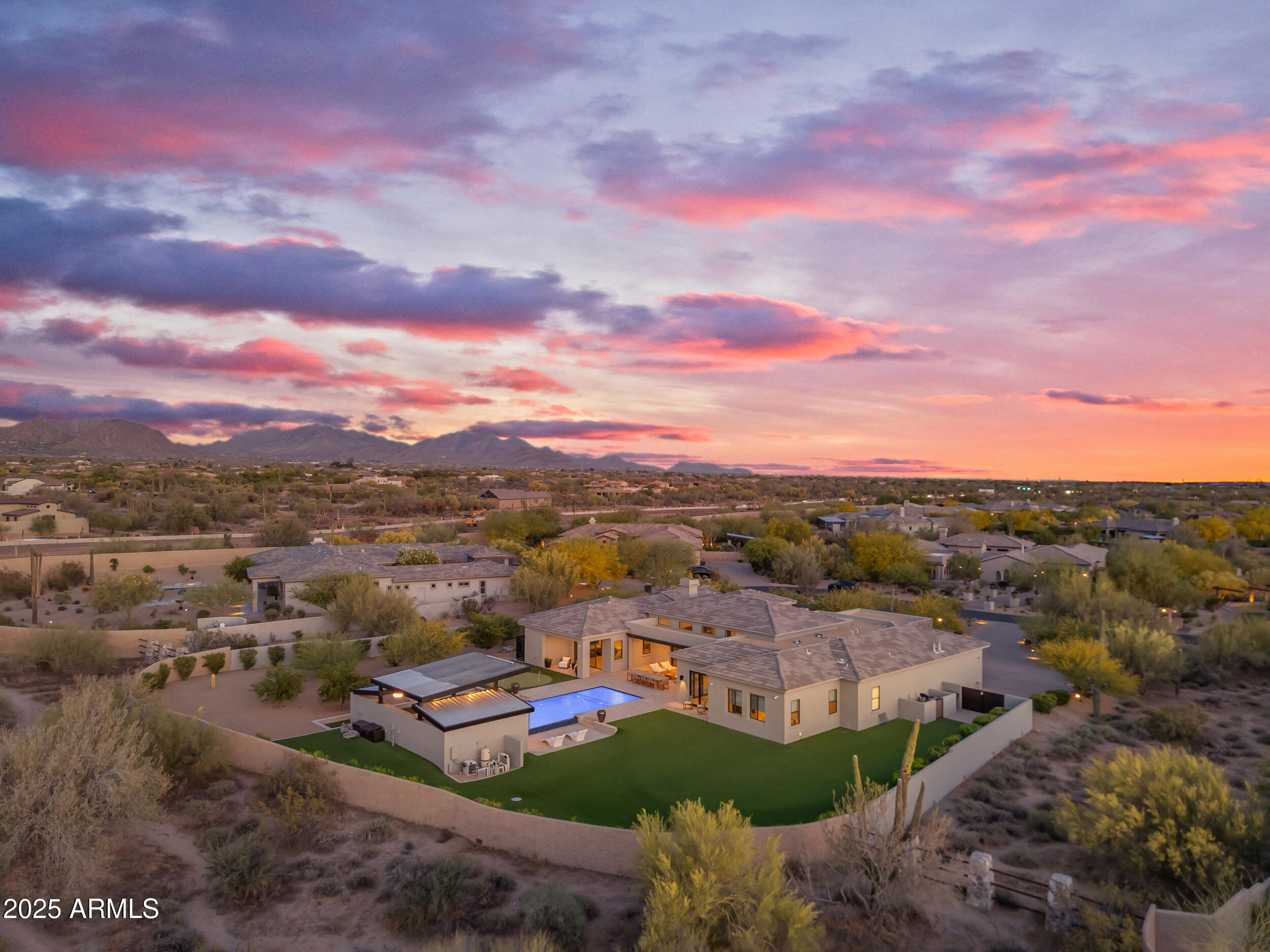 Welcome to your dream retreat on in one of Scottsdale's premier gated communities. This stunning custom home was designed for entertaining and comfort, inside and out. Step through a modern courtyard into a home that offers high-end finishes, wide open living spaces, and seamless indoor-outdoor flow.

The heart of the home features a chef's kitchen with oversized island, top-tier stainless appliances, and custom cabinetry. The open-concept great room showcases an amazing fireplace, exposed beams, and collapsible doors that open to your personal oasis.

Out back, enjoy a true resort setup with an oversized heated pool with a show stopping waterfall feature, putting green, and a full outdoor kitchen under custom steel and wood shade! Relax in the covered lounge area or by the firepit as the sun sets over the desert.

Inside, each oversized guest bedroom includes its own private bathroom. The spacious primary suite features a spa-like bath with separate walk-in shower and soaker tub, plus a massive walk-in closet. A detached casita adds flexibility for guests, multigenerational living, or a private office.

Additional features include a 4-car garage with storage space, a dedicated home office, and fully landscaped grounds. All located on a generous lot with desert views and plenty of privacy.

This is high-end Scottsdale living with everything you need and more.