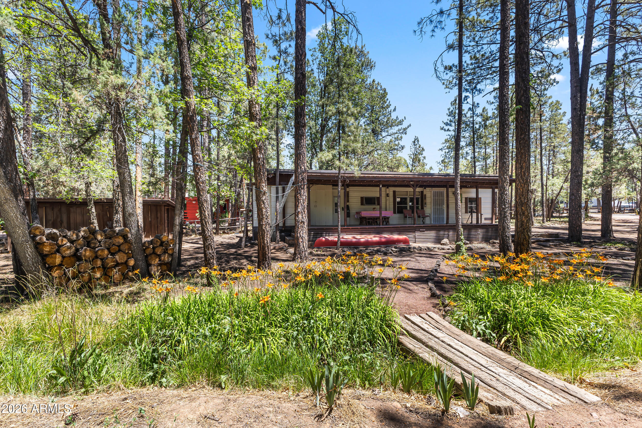 Rare opportunity to find a near original and lovingly taken care of property. It is located on a fully fenced half acre lot with two out buildings with roofs less than 5 years old. A metal roof installation was completed on the home and deck just 3 years ago. The covered deck overlooks tall pines and a small waterway running through the property. A cozy wood burning stove keeps the entire home nice and warm on those chilly nights. This quiet and picturesque property is less than a mile away from major retailers and local hospital. Don't miss out on this adorable and affordable piece of property!