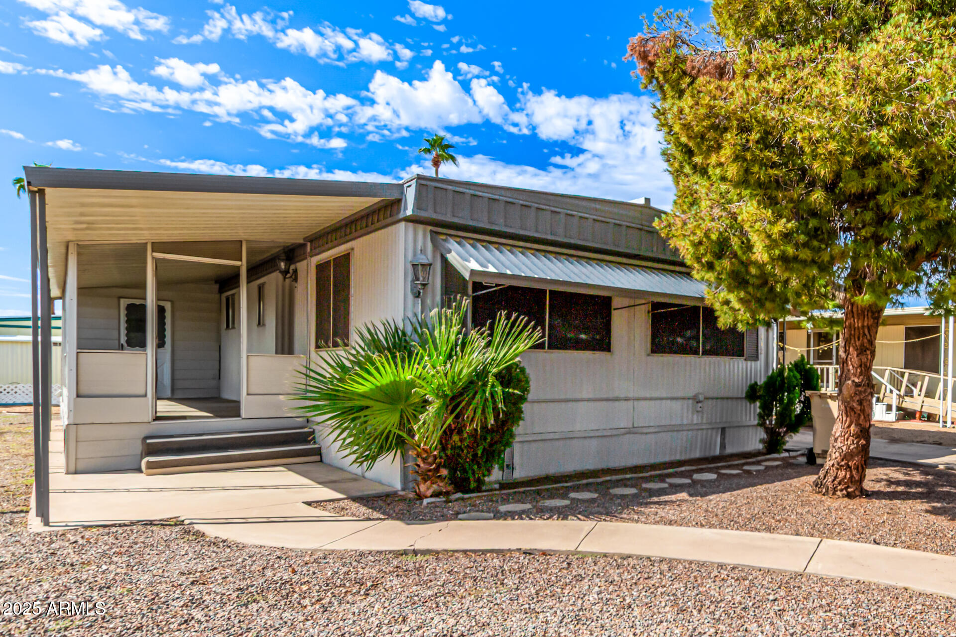 Discover this adorable manufactured home in the sought-after Friendly Village of Orangewood! Offering 2 bedrooms, 2 bathrooms, and convenient carport parking. Inside, you'll find spacious living areas with wood-look flooring, large windows for abundant natural light, and neutral colors that go with any decor. The galley-style kitchen features ample cabinetry and counter space, as well as built-in appliances for a seamless cooking experience. The main bedroom is a true retreat, complete with a closet and a private ensuite for convenience. Enjoy your morning coffee on the covered patio and don't forget to visit this welcoming adult community's features, including the pool, spa, golf, media room, and clubhouse! Hurry up, this gem won't last!