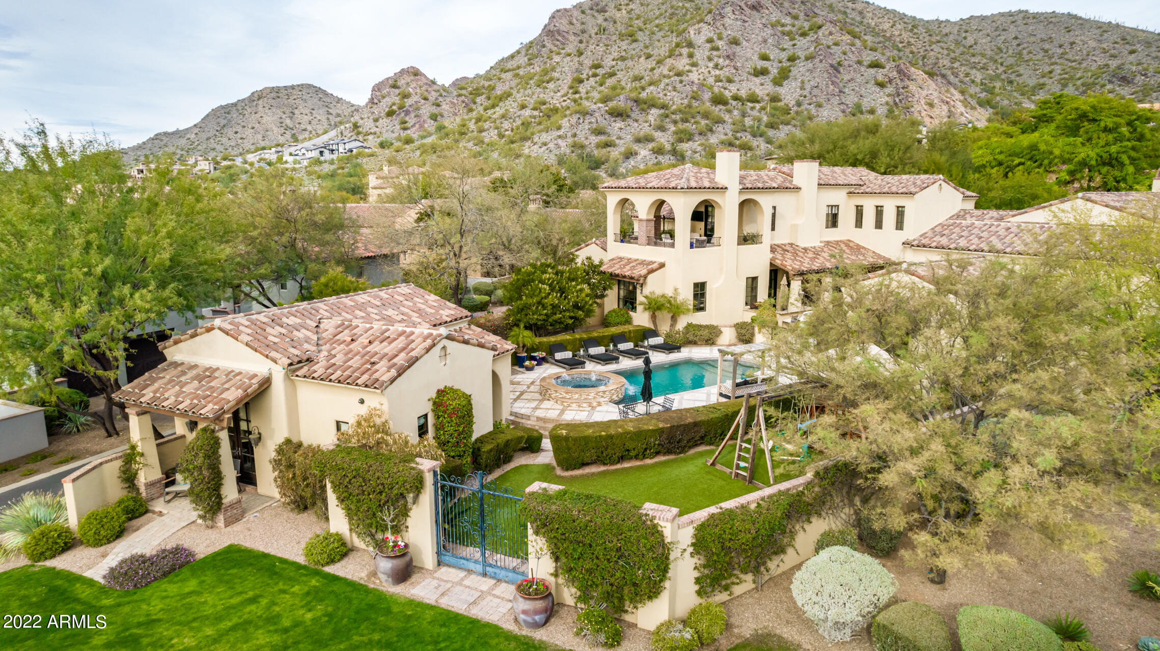 Charming traditional style estate located on a .73 acre premium lot in Silverleaf's Windgate Pass. Sophisticated and comfortable, this 6,841 sq. ft. residence comprises 5 bedrooms, 5.5 baths, dining room, custom office and private guest casita. Quality craftsmanship throughout with elegant finishes including stone and wood floors. Great room with vaulted wood beam ceiling, custom fireplace, wet bar and custom cabinetry. Chef's kitchen featuring top of the line appliances, dual dishwashers, breakfast room and wine wall. Large primary bedroom on living level with sitting/exercise room and fireplace. Spa type bath with steam shower. Flex space. Great mountain & city light views from second level patio. Resort style pool and spa, barbecue island, fireplace, large grass play area. 3 car garage.