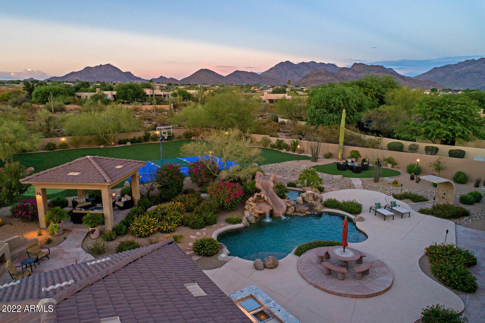 Located in North Scottsdale's Los Gatos gated community by Grayhawk and DC Ranch, this light, bright and spacious 6,780 sqft five-bedroom home sits on a large 1.73-acre lot featuring a resort-style backyard with stunning mountain views. This single-story home has an open floorplan with split master bedrooms, all en suite bathrooms, stainless steel appliances, a four-car garage, and an attached casita with separate garage entry and its own kitchen and living space. The entertainer's backyard includes a heated saltwater pebble tec pool and spa with waterfall and slide, sport court, putting green, outdoor kitchen, gazebo and a large covered patio. This North Scottsdale home is conveniently located close to the 101 freeway, golf courses, grocery stores, and upscale shopping and dining options.