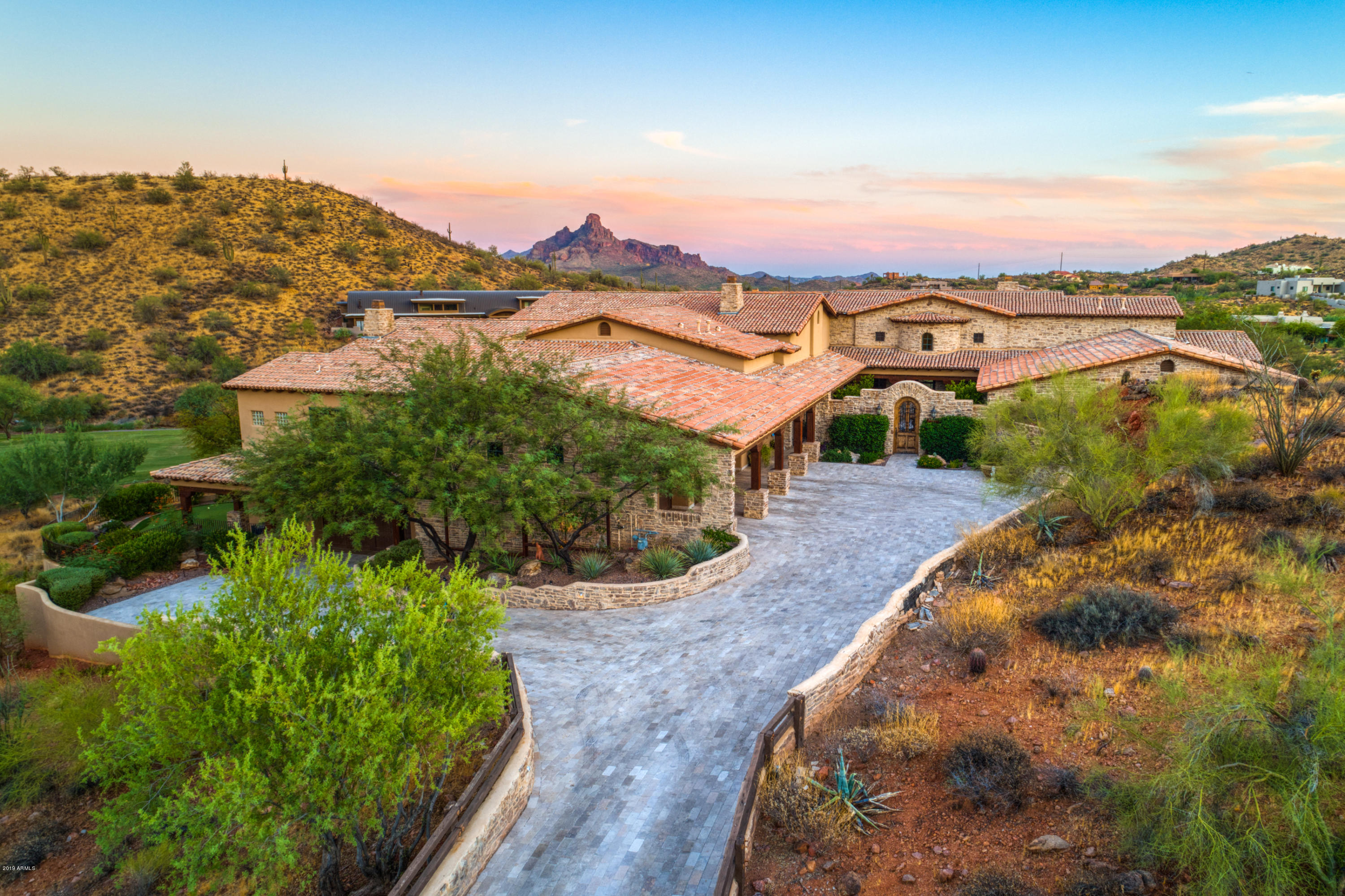 Perched above the 13th hole of Firerock Country Club's championship golf course, surrounded by awe inspiring views of Four Peaks and Red Rock, this exquisite custom estate offers timeless luxury and elegance. 

From the guarded gatehouse across a private tumbled travertine bridge sits 13,000 square feet of masterfully designed courtyards, verandas, fountains, pools and fireplaces enclosing over 9,000 square feet of living space. No expense was spared creating this extraordinary 6 bedroom, 9 bath home with soaring ceilings of rough-hewn beams, top-of-the-line epicurean kitchen, 10 foot cantera stone fireplace, 1,000 bottle climate-controlled wine cellar, theater room, private casita and multi-level, cascading resort pool on 1.78 acres of breathtaking city, mountain and golf views. SEE ADDITIONAL HOME "UPGRADES & AMENITIES" LISTED UNDER DOCUMENTS TAB