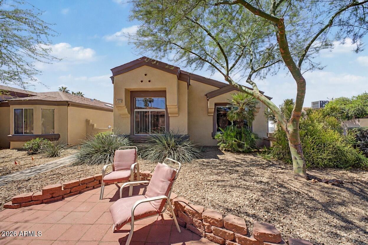 Welcome to this inviting Mojave model featuring a bright, open kitchen with white cabinetry, quartz countertops, stainless steel appliances, and a convenient breakfast bar overlooking the living area. The spacious primary suite offers plenty of room to relax, while the additional bedrooms provide flexibility for family, guests, or a home office. The home boasts updated bathrooms, including a generous guest bath with a large vanity and shower/tub combo. You'll also appreciate the inside laundry room and ample storage throughout, including a well-organized walk-in closet with shelving. Step outside to enjoy your private backyard oasis, complete with a covered patio and low-maintenance desert landscaping with mature plants, cacti, and colorful accents--perfect for entertaining.