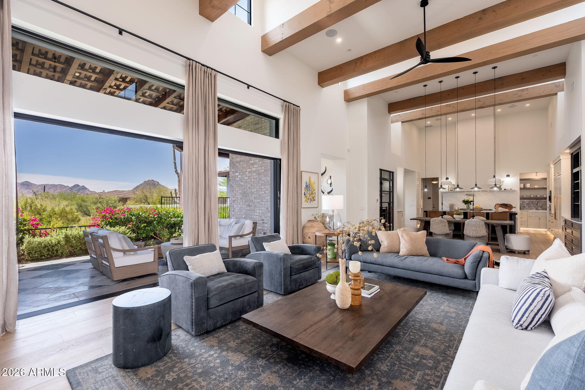 First time offered, this 2023 custom estate in the gated community of Troon Verde seamlessly blends French country warmth with a sophisticated industrial edge.  Timeless and elevated designer finishes throughout this beautiful light-filled home. Exposed solid wood beams, French oak wide plank flooring, and a mix of classic and contemporary, with natural stone, warm woods, and a tailored mix of metal finishes define the home's unique character. Curated designer lighting is a central component of the home's charm, with Visual Comfort and Restoration Hardware, and integrated ambient lighting throughout, exuding timeless understated luxury. The great room is anchored by a stunning limestone Isokern fireplace, which is framed by custom built-in shelves, cabinetry and a daybed. A 20-foot window wall disappears into a pocket wall, merging the great room with a generous checkered marble and limestone covered lanai.  Multiple covered patios and resort-style PebbleTec pool with cool limestone decking, firepit and outdoor kitchen built for entertaining, make for numerous gathering areas and a boutique hotel feel. 

The main entry greets you with a dedicated foyer and striking large-scale marble in black & white checker. Or, enter through the motor court's European-style iron and glass French doors.  Abundant windows and glass doors throughout the home showcase the beautiful desert and mountain views. 

The chef's kitchen with endless storage features BlueStar column fridge & freezer, and 6-burner gas range with griddle, pot filler, Miele built-in coffee system, Wolf microwave, dual beverage refrigerators, pantry fridge drawers, and a Hoshizaki ice machine. Custom cabinetry showcases furniture-quality craftsmanship with refined panel detailing, elevated by warm unlacquered brass hardware and integrated under-cabinet and toe-kick lighting throughout. 

A temperature-controlled 500-bottle wine room serves as a stunning focal point, while the adjacent prep pantry with additional sink and storage enhances both everyday living and entertaining. The main laundry and mud room have direct access from the garage into the kitchen and offer ample cabinetry and storage. 

The home's outdoor setting is thoughtfully appointed, with high-quality synthetic turf, bocce ball court, Belgard paver hardscape, and expansive covered patios with beam detail and integrated lighting.  Lush landscaping with landscape designer's careful blending of blooms, including gorgeous Bougainvillea vines trailing over the expansive front wall, palms beside the pool and a variety of blooms native to the Sonoran desert. 
Privately positioned, the primary suite is accessed through grand French carved wood doors and captures breathtaking McDowell Mountain views. 

The spa-like primary bathroom is thoughtfully designed with floating vanities, designer fixtures, dual water closets, heated floors (second primary bathroom has heated floors as well).  Don't miss the large custom closet with integrated washer and dryer and private patio off the primary bath, complete with outdoor shower and sitting space for all the wellness needs.

The home offers exceptional flexibility with three en-suite guest bedrooms, each with walk-in closets and separate access to backyard patios. A spacious bonus room off the kitchen provides the perfect space for an office, media room, or game room. The attached casita is a fully independent living space complete with its own kitchen, living room, bedroom, bath, exercise room, and also private access from the garage, motor court, and backyard, making it ideal for a rental or multigenerational living.

Additional highlights include pre-wired sound system throughout, central vacuum with multiple ports and in-wall retractable hoses, 240V EV charging, epoxy-finished garages - one over-height and extended length. Built with quality and efficiency in mind, the home features high ceilings, solid core doors, upgraded insulation, dual-pane Low-E windows, and high-efficiency systems. Located within a short walk to the Brown's Ranch trail (trail access on 114th Street) and the McDowell Sonoran Preserve for hiking and biking enthusiasts.