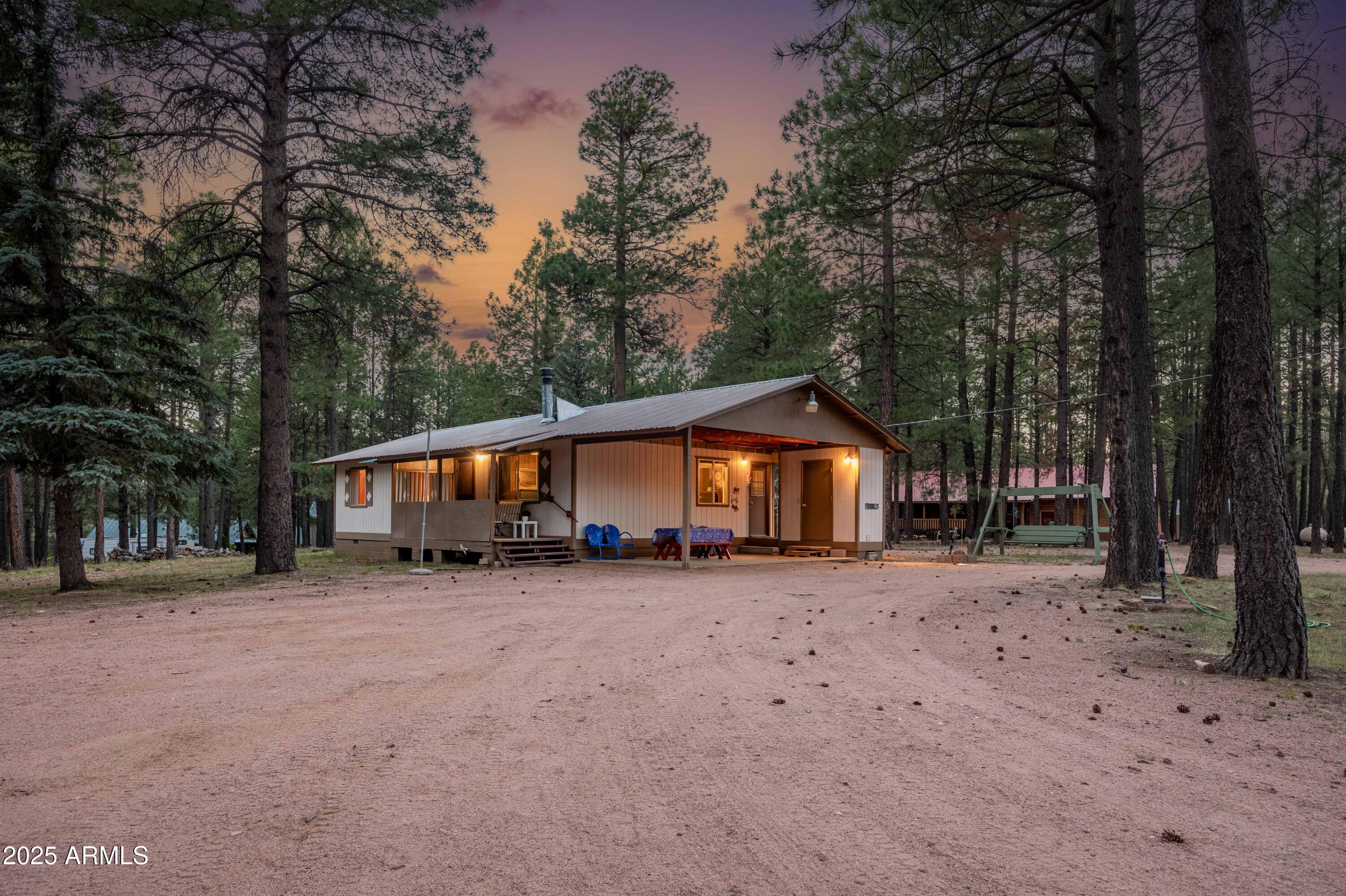 Nestled among towering Ponderosa Pines this charming 1,056 square foot cabin at 2190 Old Rim Rd offers a perfect blend of rustic character and practical living. Set on a generous 1.05-acre lot, this three bedroom, one-bathroom retreat provides ample space to create your mountain escape. The cabin's great room serves as the heart of the home, featuring a wood-burning fireplace that creates a warm, inviting atmosphere during cool Arizona evenings. The eat-in kitchen provides functionality while maintaining the cabin's cozy aesthetic. A spacious storage room offers versatility - envision transforming it into an indoor laundry area or expanding the primary suite with an additional bathroom. Outdoor living is emphasized with a welcoming porch perfect for morning coffee while taking in the natural surroundings. The property's expansive grounds provide numerous opportunities for gardening, outdoor recreation, or simply enjoying the forest setting. Gather around the backyard fire pit on summer evenings for storytelling and stargazing with family and friends.

Practical amenities include a convenient storage shed for outdoor equipment, circular driveway & covered carport offering abundant parking for residents and guests. Plus an RV spot with 30amp hook up, water access and rv dump. The property includes laundry hookups, ensuring modern convenience in this mountain setting.

Forest Lakes Estates presents an idyllic location for nature enthusiasts, with nearby lakes providing exceptional opportunities for fishing, boating, and waterfront relaxation. The absence of HOA restrictions allows homeowners complete freedom to personalize their property according to their vision. There is also a full time Fire Dept. / EMS, community center, library, 2 general stores and restaurant/bar. If you need more options make the 20-30 min commute to Heber or back to Payson.

Act now to own a piece of Arizona's mountain heritage while creating new memories in a tranquil forest setting. The home is rich in history yet ready for new beginnings, this cabin awaits your personal touch to transform it into your ideal mountain retreat.