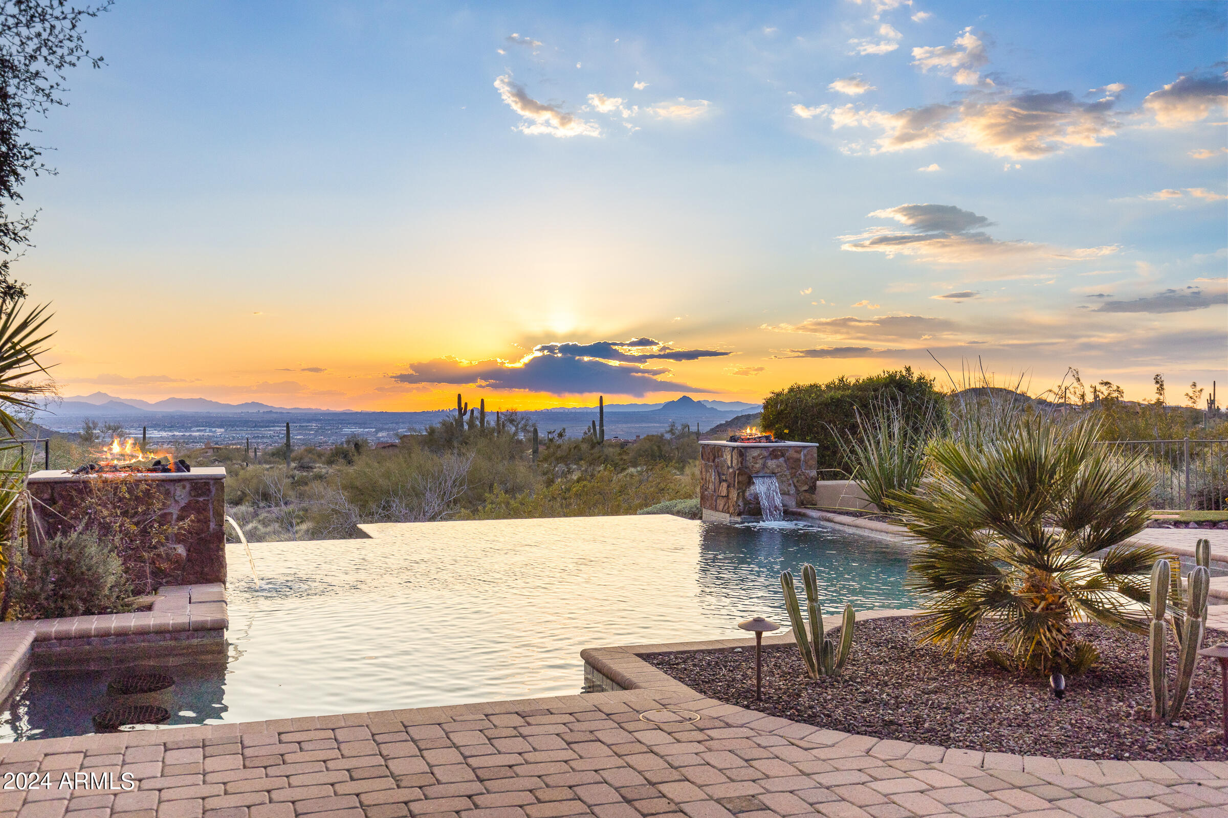 This stunning property offers the most amazing views of both the mountains and the city lights!  As previously showcased in Phoenix Home and Garden Magazine, the 4 bedroom, 5.5 bath home with separate casita offers designer upgrades and amenities throughout.  Enter into the home and you'll be taken back by the unobstructed views overlooking the magnificent pool, spa, outdoor fireplace, grill, putting green and spacious decking.  The kitchen offers lots of cabinetry, large walk-in pantry, 3 ovens, tons of working space and lots of room for entertaining as it opens to the great room.  The theatre room, office with built in bookcases, exercise room and spacious floorpan make this home a perfect fit for any size family.  The master has a fireplace, custom shelving and doors to the exterior... for an easy escape to the private spa.  The HUGE master closet offers tons of storage, large bath with walk in shower and adjoining exercise room are added features.  Two additional en-suite bedrooms are on the other side of the home along with the laundry room, large storage closet and garage entrance.  The oversized 3 car garage has built-in cabinets and offers an air conditioned storage room which houses the AC units.  Dont forget about the casita with separate garage!  The curb appeal, exterior features and location of this 1.1 acre lot cant be duplicated - this is truly a special house and a rare opportunity to live in Diamond Point!