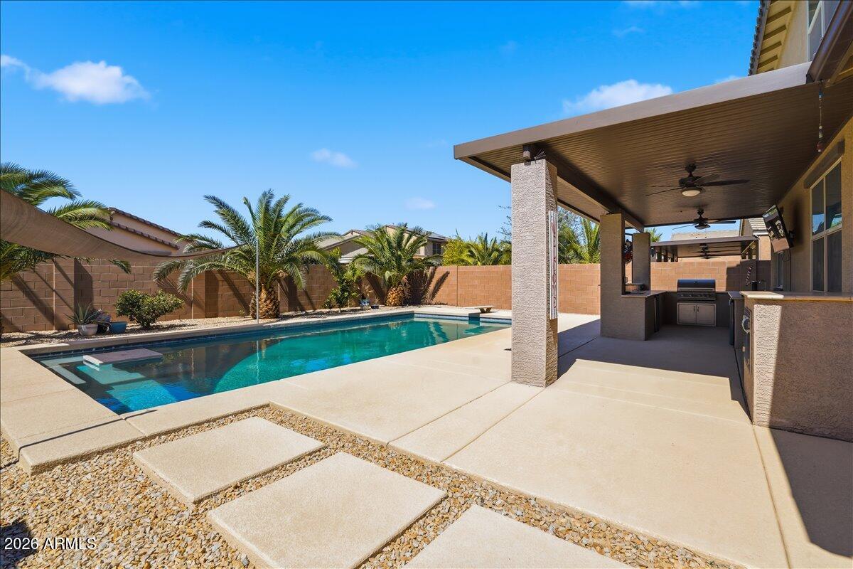 Welcome to the City of Maricopa, where resort-style living begins in your own backyard. This beautiful two-story home showcases an exceptional outdoor retreat designed for Arizona living. The centerpiece is a sparkling diving pool complemented by a fully equipped outdoor kitchen, creating the perfect setting for relaxing, entertaining, and making memories year-round.Inside, you'll find 5 spacious bedrooms, 2 full bathrooms, and 1 half bath, along with a dedicated office and versatile living spaces on both levels to accommodate work, play, and everyday living. The open-concept floor plan features tile flooring throughout the main living areas, offering both style and easy maintenance. Additional highlights include a water softener system and a 3-car tandem garage with ample storage.