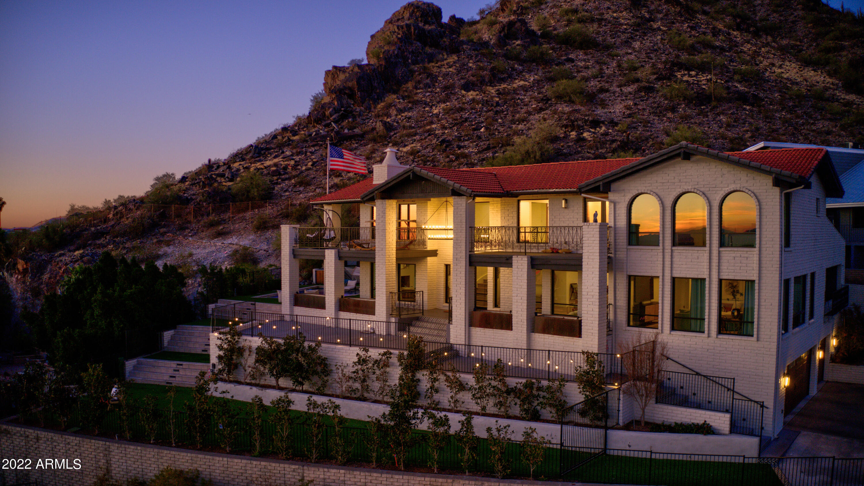 This stately home is a Phoenix landmark, with its iconic white columns and lights adorning the hillside adjacent to the renowned Phoenix Mountains Preserve. Known as Casa Bella Vista, this home has the feel of a world class sanctuary, ideal as a luxury vacation rental or home retreat. With a five-star, rave review history on Airbnb/VRBO, this is a golden investment opportunity. As soon as you walk up to the entrance you are greeted by sweeping 270-degree views extending throughout the valley from Downtown Phoenix to Piestewa Peak. Welcome to your own Five Star Resort! 

Nothing was overlooked during the recent $1.3M+ renovation project—only high-end materials and finishes were curated to showcase the best in modern desert living. Four levels of exterior areas, inspired by the dramatic secluded settings of Utah's Amingiri, allow for extraordinary entertaining. 
-Retreat to your private resort-style pool and jacuzzi nestled against the mountains featuring breathtaking views of the mountains and the valley. On one side are the lights of the valley, on the other side is the glow of the mountains. 
-A custom-built putting green allows golfers to perfect their putting game. The custom fire pit lined with high-end tiling creates a stunning backdrop for winter entertaining. 
-A lower landing, lined with magnolias , allows a secluded gated area for large events or for pets to play. 
-Solar lights on the mountain provide an effortless and environmentally friendly nightly illumination of the mountain in your backyard

Inside the expansive home, enjoy a spacious retreat with refined touches throughout.
-The chef's kitchen is an entertainer's dream complete with built-in Miele appliances and a jaw-dropping leathered double-waterfall Taj Mahal island.
-The real hardwood flooring blends seamlessly with the natural environment. 
-The sophisticated glass wine wall in the formal dining room is sure to impress any dinner guests. 
-The expansive master suite features a tiled bathroom and a solid terrazzo tub so heavy it had to be craned over the roof into the bathroom. Also featured in the master suite is an unparalleled walk-in closet worthy of the Real Housewives and a 270-degree private outdoor terrace. 
-The expanded laundry room includes double washers/dryers, dog bath, and sink.
-Three expansive terraces each offer unique vistas. Each bedroom offers private terrace access.
-Each bathroom was extensively remodeled with unique features from a Turkish soaking tub in the upstairs guest bathroom to a door-less walk-in shower for the pool bathroom, easy to use for large summer events. 

Beyond the landscape and architecture, the ultimate feature of Casa Bella Vista is the way in which our Valley sunsets bathe the home in colors that simply take your breath away. This sanctuary of a home is in the heart of town less than 5 minutes from the world-class shopping, dining and entertainment of Biltmore Fashion Park. Casa Bella Vista invites you to enjoy your slice of paradise.