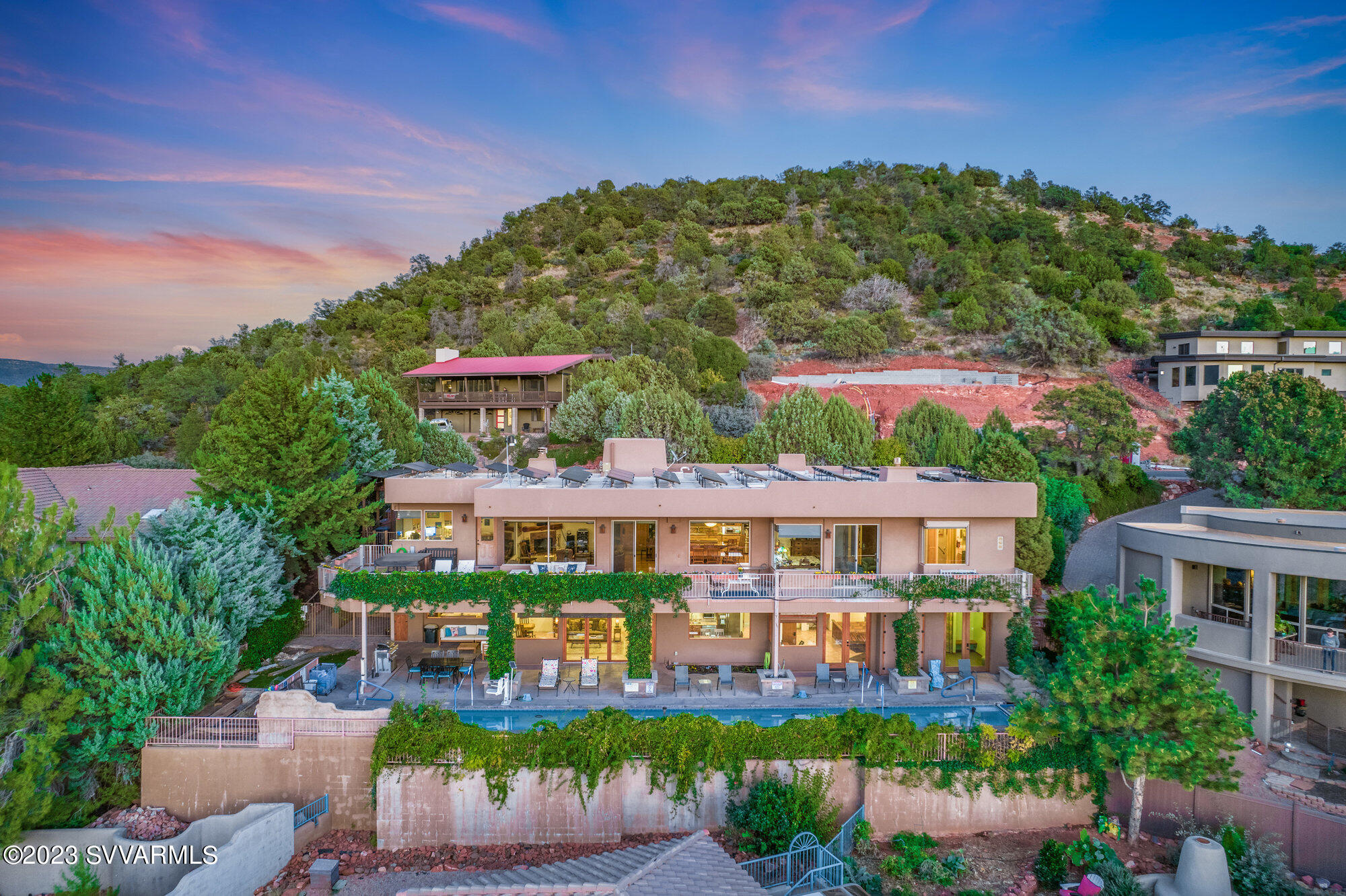 Extraordinary Sedona Showcase home featuring breathtaking views of Sedona's iconic red rocks. This custom built dream home is perfect for retirement and as a savvy investment. This property offers the best of Sedona's Lifestyle with unique features that include custom floor to ceiling seamless windows, multiple outdoor decks, a lush front courtyard and a backyard that boasts a private custom tile 25 yard lap pool with endless red rock views. 
The upper level great room opens to a gourmet  kitchen, marble countertops, and a pass-through window that opens to the courtyard trimmed with beautiful iron gates, roses and plush grass creating a private oasis.
The lower level is an active Luxury STR with expansive views, pool side deck and a fitness room. Sale includes STR furnishings. Upper level - currently owner occupied
Lower level - active 2 bedroom luxury short term rental  

Features: 
 
Upper level -
Unparalleled Sedona Red Rock views from upper living, kitchen,  bedrooms and master bathroom
Custom seamless windows for optimal red rock panoramic views
High beamed ceilings create a well appointed and spacious great room
Beautiful cherry wood flooring
Marble two tiered kitchen counter with breakfast bar
Custom pass through services window from the kitchen to the front courtyard
Stainless steel and laundry appliances included
Upper deck access from Master Bedroom, Living room and North guest Bedroom
Front Courtyard access to one of the south side bedrooms creates a perfect entrance for private studio

Lower level -
Luxury short term rental with iconic red rock views from the living room, kitchen and both bedrooms. 
The kitchen opens to the living room and red rock views are outstanding. 
The split floor plan is perfect for guest enjoyment featuring floor to ceiling window doors  in the living room that open to a walk out to the swimming pool deck. 
Granite counter tops in kitchen and bathrooms
2 spa-like bathrooms
Heating - mini splits 
Radiant heating flooring
All lower level furniture, fixtures and equipment included in the sale

Fitness room - The lower level also has a separate fitness & pool changing room combo with shower and bathroom that has a separate entrance to the pool deck. 

Extras: 
Energy savings and EV charging -
60 panel owned solar system
2 EV owned charging stations (not Tesla) 1 located in garage and in car port side, 1 located at street paver parking area
Internal elevator for access between Level 1 and Level 2. 

Laundry rooms and central vacuum systems -
This home has 2 laundry rooms. One located on each level. W/D's included. 
2 central vacuum systems; 1 upper level, 1 lower level

Pool and Spa: 
25 yard lap pool with beautiful custom tile, can be saline, currently chlorine, remote pool cover, swim lift, equipment, heater, pool cover
Operational pool equipment included
Spa: located on the upper deck

Outdoor patio furniture included:
Upper Sofa and table set
Lower deck chaise lounge chairs, sectional and chairs, table set
One BBQ located at lower deck included

The pool deck access: 
Exterior north ramp on the side of the car port
Exterior south stairs on the south side of the home
Interior access from upper level elevator
Interior access from the lower level from the living room, both bedrooms and fitness room. 
See floor plans 

Handicap accessible: 
Entire upper level is accessible at ground level featuring wide doors and hallways.
Swimming pool has swim lift