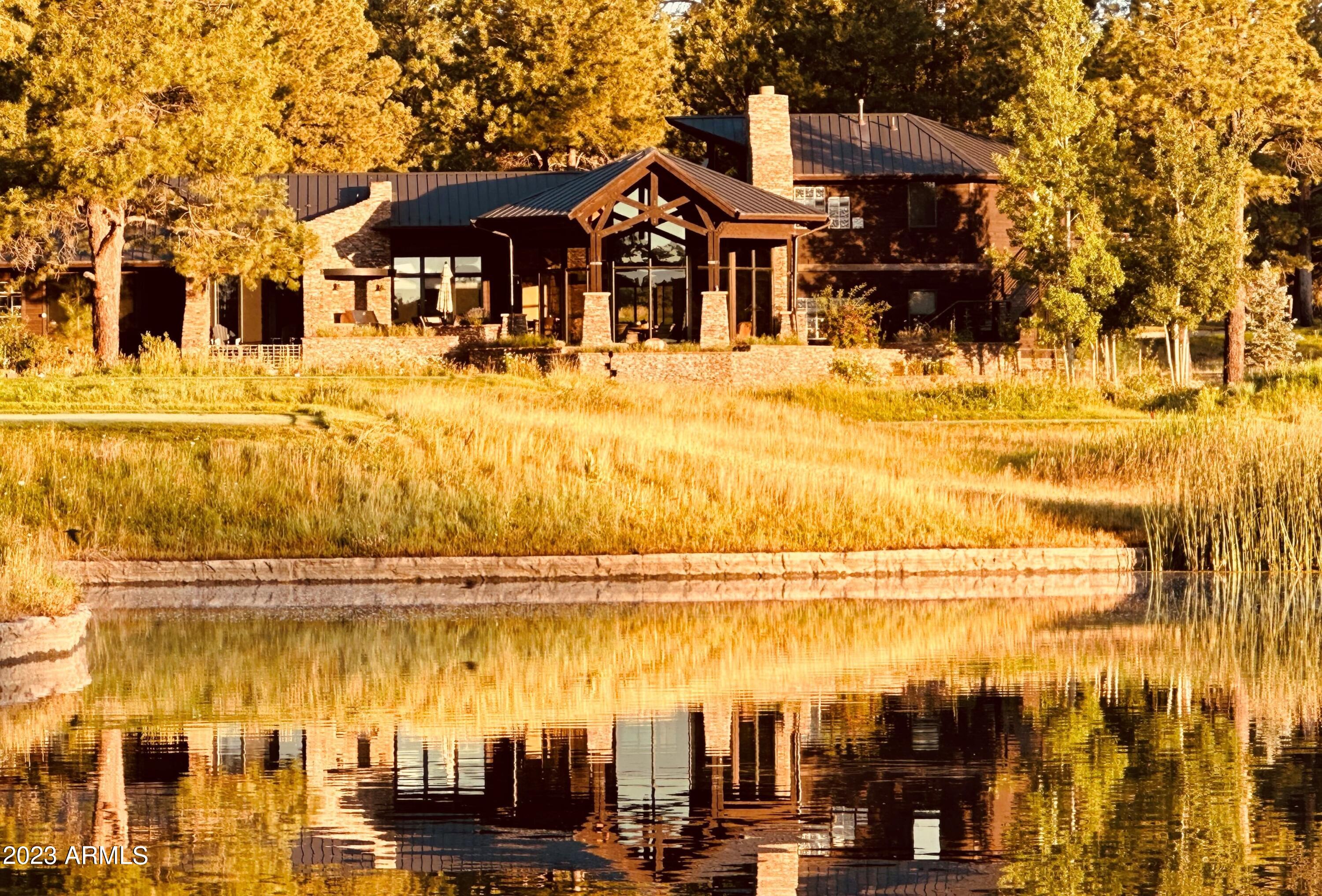 Welcome to this exquisite mountain modern home, where rustic elegance harmonizes with breathtaking surroundings. Nestled in a tranquil setting, this property offers captivating golf course and lake views, creating a true sanctuary for the senses. As you step inside, you'll be captivated by the seamless blend of natural elements and contemporary design. The open-concept living area boasts polished concrete floors massive stone fireplace, gorgeous bar area and large windows that frame the picturesque vistas, inviting the outside in and bathing the space in natural light. The heart of this home lies in its chef's kitchen, a culinary haven equipped with top-of-the-line appliances, ample counter space, large walk-in pantry, temperature-controlled wine room and exquisite finishes. Whether you're an experienced chef or an aspiring food enthusiast, this space will inspire you. The exterior of the house is adorned with a stunning copper roof, adding a distinctive touch that complements the natural surroundings. Immerse yourself in the serenity of the mountain environment from the expansive outdoor living spaces. Enjoy the awe-inspiring views as you relax on the patio or entertain guests.