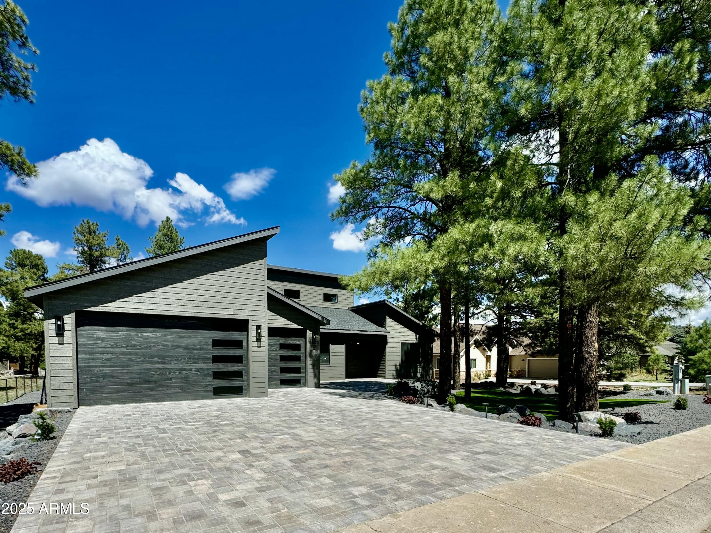 Huge Price Reduction on this STUNNING NEW Custom Home in the Elephant Rocks Golf Community of Highland Meadows.  Welcome home to sophisticated luxury inside & out- Enjoy the large Great-Room featuring 23ft vaulted beamed ceilings, transom windows, elegant gas fireplace, spacious living & dining areas, & 16ft sliding glass doors opening onto 550sqft covered trex-deck.  An impressive Kitchen includes ZLINE appliances with 48''Gas-range & Dual ovens, 60'' Fridge/Freezer, Custom Cabinetry, elegant backsplash & large Quartzite waterfall island. Home fully Prewired for security, surround sound & electronics. 2 AC UNITS +AC & Heat in garage! Master bedroom has deck access, upgraded walk-in closet, en-suite w dual vanity, soaking tub, large shower w dual shower heads/controls & heated towel rack. Oversized guest rooms also have California closet systems (similar to Master closet) & are prewired for wall mounted TVs. Both baths 2 & 3 feature elegant tile work. 
The inviting Backyard features covered patio deck perfect for entertaining & a grand staircase leading down to the peacefully landscaped backyard with 2000 sq ft of premium Turf, accent boulders, & prewired for landscaped lights & irrigation, plus fully fenced for pets. RV gate & under deck storage make storing toys a breeze.  
The front yard is picture perfect with premium Turf, landscape lighting, irrigation to plants & trees, boulders, & oversized Belgrade pavers on driveway & entry. 
Everything about this home is carefully designed & upgraded... From the raised driveway & foundation to prevent snow pile, to the 5+ car temperature controlled garage for all your vehicles & toys, upgraded spray foam insulation (ceiling and walls), ducting, upgraded plank tile flooring, & dual AC units for comfortable summers, to the Composite siding w 50yr paint guarantee, powder-coated deck railing that will never rust, & Upgraded lighting both inside & out. It also features a Steel Front Door with keyless entry, oversized garage doors, Solid core interior doors, Metal framed windows, ZLINE appliances (range, oven, microwave & dishwasher), plus under cabinet lighting in kitchen and pendant lights at island, plus upgraded single basin kitchen sink (with Insta Hot water), pop up outlets in island with wireless phone chargers, Kohler sinks at baths & water closets prewired for electrical (for heated/automated toilet plumbing). There is recessed lighting thru out, ceiling fans with remotes, side yard garage access, fully equipped laundry with new washer, gas dryer & laundry sink, tankless gas hot water heater, AC and Heat in garage, plenty of storage, lots of natural light & so much more!
Nestled in the tall pines, steps from National Forest & surrounded by Elephant Rocks Golf Course, this beautiful Mountain Retreat has well designed and thoughtful amenities & is move-in ready. All within minutes of downtown Williams with shopping, dining & entertainment. Come see the best of Modern Elegance in the Pines.