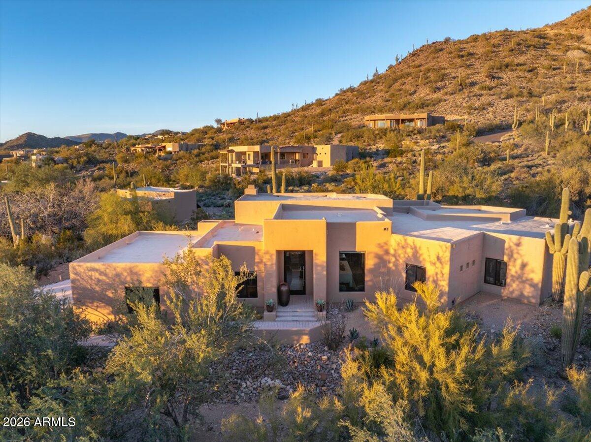 Located in the highly sought-after Carefree Foothills subdivision.This beautifully remodeled home with numerous upgrades is nestled against the mountainside, offering breathtaking desert and mountain views through expansive picture windows that fill the interior with natural light. The open-concept floor plan is designed for effortless entertaining, featuring a chef's kitchen with impressive double islands, a dry bar, and seamless flow into the dining area and great room anchored by a warm brick-surround fireplace. Car enthusiasts will appreciate the climate-controlled three-car garage with a workbench and extensive built-in cabinetry. Professionally landscaped for privacy & seclusion, yet just minutes from shopping and dining. When you arrive at home this is a place you can truly exhale.