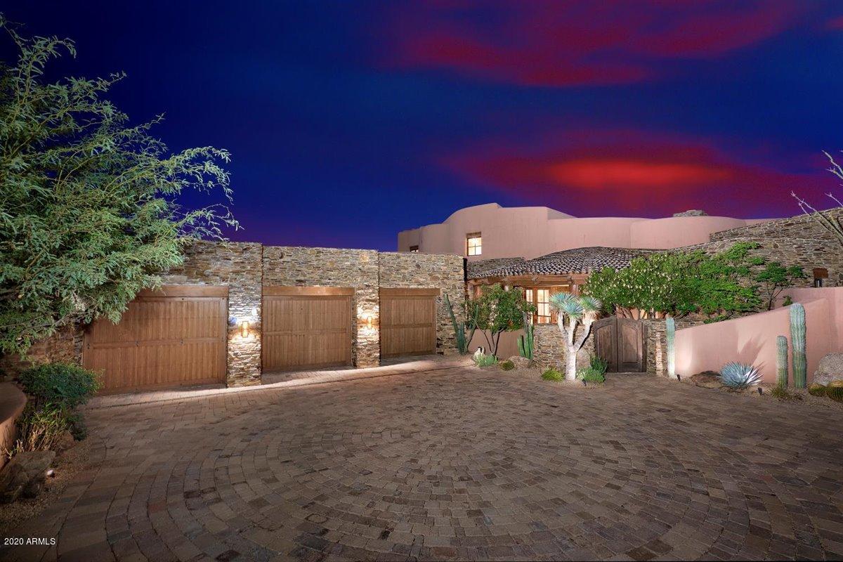 Welcome to Cochise-Geronimo 12 & 13, an unusually well-conceived and executed 8,800 square foot estate, located on 3.2 acres with wonderful views in one of the most desirable ''Villages'' in Desert Mountain, a 34-year-old, highly acclaimed 8,200 acre golf and recreation-oriented master planned development in north Scottsdale, AZ.  Desert Mountain's private club offers its members exclusive access to seven Jack Nicklaus Signature golf courses, one eighteen hole par-3 course, seven clubhouses (including a new swim, tennis, fitness, spa, croquet, bocce, and pickleball complex), ten dining venues, personalized service, and access to a crowd of fun people from around the US and Europe.  Club Membership is not included but can be acquired separately from the Club upon successful application. Desert Mountain is a "stand out" lifestyle-based place in which to live.  And, this particular property is easily one of the most elegant and gracious residences out of the nearly 1,900 homes that have been built so far in the development.  No lots remain for sale at a sensible price that offer this property's combination of size, privacy, views, convenience to Club facilities, and ease of ingress and egress.  

In a word, it is "superb".     

The property has two closely adjacent custom-designed residences, sharing a 2,500 square foot, southwest-facing back patio with a fireplace and a firepit (more "Plaza" than "Patio"); one "Main Residence" of 6,580 square feet, and one "Guest Residence" (not merely a "guest house", or "guest casita", but a true "residence", regarded by the owner as more of a Game Room given its most frequent use!), of 2,223 square feet.  Both are light and bright and are of timeless architectural design.  Construction materials used are timeless, too: wood (garage doors, architectural accents, corbels and squared off ceiling beams as well as round vegas and latilla ceiling treatments, cabinets, flooring (hickory and oak), plantation shutters); granite countertops; marble shower tile; wood stair treads with ceramic tile accents; clay ceiling tile; brick ceiling accents; iron or oil-rubbed bronze cabinet and door hardware; a custom, curving iron handrail; custom iron chandeliers; vinyl-clad wood windows; Venetian plaster walls; brick driveway paver stones (set in a circular design); and stucco, all in earth tones with natural curves and soft edges.  Only the guest bedrooms have carpet.  The lighting is wonderful, too with extensive directable art lighting, recessed cove lighting, recessed path lighting, and soffit lighting in the ceilings above bed headboards.  As a result, it is a great residence in which to showcase hanging art, sculpture, or other collectibles.


Designed by perhaps Desert Mountain's most celebrated architect, Lee Hutchison of Urban Design Group (with at least forty-seven homes to his credit within Desert Mountain), and built by two of Desert Mountain's most respected builders, RS Homes and Manship Construction, the residences have as good a design and construction "pedigree" as you will find.  And, having them set on 3.2 acres (previously two separate lots, which were legally combined into one in 2014), in the middle of close to five acres of quiet (no noisy roads or golf courses nearby) lush, High Sonoran Desert that can't be further built upon, at an elevation of approximately 3,100' above sea level, lets them deliver a remarkably enjoyable living experience.  The property offers wonderful "setting" characteristics as well as "perfect" framed views to the west/southwest of fall, winter and spring sunsets, some city lights on the distant valley floor, a couple of close-by mountains, and numerous mountain ranges as far as eighty miles away.  

The front door of the Main Residence is about 480 yards away as "the crow flies" to the front door of the Desert Mountain Club's "main clubhouse", the 52,000 square foot, iconic, Cochise-Geronimo Clubhouse, where two golf courses start and stop and where one of the Club's four terrific, double-ended golf practice ranges is.  "Convenient" does not quite describe this property's location with respect to one of the main reasons most families would consider wanting to own it  easy club access.   

The Main Residence, built in 2005, offers: a "Kitchen/Family Room" layout (which the owners describe as a "Kitchen/Morning Room" layout, since they have another room they call the "Family Room", a relatively large gathering room with a fireplace, a large flat-screen television, many feet of recessed, lighted, lateral shelving for books or collectibles, and a more-than-generous built-in workstation/desk with upper cabinets and lower drawer storage.  The space could be called a "Second Office" or perhaps a "Media Room/Home Theater" with the addition of some theater seating and a larger screen.  The Morning Room is great, but the Family Room adds a terrific additional place to gather and relax.  Master Suite with fireplace and hearth, separate baths (heated towel racks, ceiling heat lamps, and a heated toilet on "Her" side) and separate dressing rooms (with appropriate first-class, crown molding-topped closet fittings); two other guest bedrooms on the opposite side of the home that share a small "living room" equipped with an alcove wet bar/kitchenette (creating essentially, a three-room "casita" inside the home); indoor and outdoor exercise studios; one office upstairs, complete with shower bath; a cedar-lined out-of-season clothes storage closet; one three-car garage with an air-conditioned storage room; a well-equipped (gas range-top) working Kitchen with a large center island complemented by an additional powder room and the previously mentioned Morning Room; an artificial-grass-covered dog run (washable), completely enclosed by wire mesh (sides and top) to protect pets from any predators who would do them harm, accessed by a proper "doggie door" (and the property is within easy walking distance of Desert Mountain's popular Dog Park); a Wine Storage room large enough for several hundred bottles; a well-covered outdoor barbeque patio/outdoor living room, equipped with a television and one of the six fireplaces and a firepit the property boasts; a spare  refrigerator in the laundry room (to support large gatherings).  There is a large negative edge pool on the back patio, with a separate spa, both covered with Pebble-Tec.  


The Guest Residence, built in 2014, offers: a separate driveway approach, an open "Great Room" layout, with the living area large enough to support a sizeable seating area in front of a large television and fireplace PLUS a big area for a ping-pong table or billiards table, next to an adjacent kitchen area with desk.  Want an air hockey table?  There's room for that, too!  There is also an outdoor shower, an attached one-car garage, and heaters in the ceiling over the outdoor dining area.  


The property's landscaping is impeccable, in keeping with the tone and "presence" the home's architecture, siting, size, capabilities, and location project upon first arrival. 


The roof was recoated in 2018 and carries a ten-year, transferable warranty.  Most of the furniture is available separately.  It has been continually managed and kept up to high standards by a professional firm.  


Desert Mountain is in a very quiet, serene, safe, secure and beautiful location, spread east to west across the foothills of the Continental Mountains on the northern edge of Scottsdale, with homes at elevations ranging from 2,600' to 3,500' ASL.  Thousands of giant Saguaro cacti create a very distinctive landscape, a "signature look" for Arizona and the desert Southwest.  All Desert Mountain owners enjoy the use of a nearly twenty-mile long private trail system in the mountains at the back of the development for hiking, running, and mountain biking. The trails get up to 4,500' ASL and enjoy amazing panoramic views out over the entire Valley of the Sun.   Members of the Desert Mountain Club can rent horses for trail rides.  Seven golf courses (six Jack Nicklaus Signature championship golf courses and one eighteen-hole par-3 course), four practice ranges, and a high-tech golf performance center cover the golf needs of Club Members.  


The Club has seven major clubhouses with ten different dining venues for the exclusive use of its Members.  The "Sonoran Clubhouse" is the Club's fabulous swim (three pools), tennis (nine courts, including one grass, five Har-Tru, and three cushioned hard courts), fitness, spa, pickleball (six courts), bocce (two courts), and croquet facility (two courts).  It also has a popular indoor/outdoor restaurant.  It was completely renovated during 2016 and 2017 at a cost in excess of $12,000,000.  It is now perhaps the premier facility of its type in the entire Southwest.  The other clubhouses are special in their own rights and combine to provide a terrific range of experiences for the Members.  A membership to the Desert Mountain Club is not included but is available from the Club. 
 

Real estate taxes are low, only $11,169.08 for this home in 2020.  


Desert Mountain's weather is famously dry and sunny.  Our risk of natural disasters is extremely low.  Being higher and removed from town means stars are bright at night, the air typically much cleaner, and the daytime high temperatures about ten degrees cooler than the Valley floor, every day.  Summers are enjoyable since it only gets over 100 degrees about ten or twelve days a year here, compared to ninety days downtown, with humidity low.  At night in the summer, the temperatures drop fifteen to twenty degrees, a significant difference from life on the Valley floor.  Being in Desert Mountain on a year 'round basis is a very attractive proposition.  


Day-to-day shopping needs for Desert Mountain owners are well-handled within about a ten-minute drive by the merchants in the nearby towns of Carefree and Cave Creek.  There are roughly 70 restaurants and bars within about sixteen minutes' drive.   Our area is famous for world-class shopping, major league and collegiate sports, terrific air service, and a wide variety of cultural attractions.  Desert Mountain's Main Gate is about a forty-five-minute drive to Phoenix Sky Harbor Airport.  Private jets come and go from Scottsdale Airport, about a twenty-five-minute drive from the Front Gate.  Desert Mountain is within two and a half hours by car of normally excellent snow skiing in Flagstaff and offers easy access to the entire American West, including San Diego, Los Angeles, Las Vegas, the Grand Canyon, Lake Powell, and a plethora of unbelievably beautiful places in Southern Utah.  "Paradise" does not overstate it.