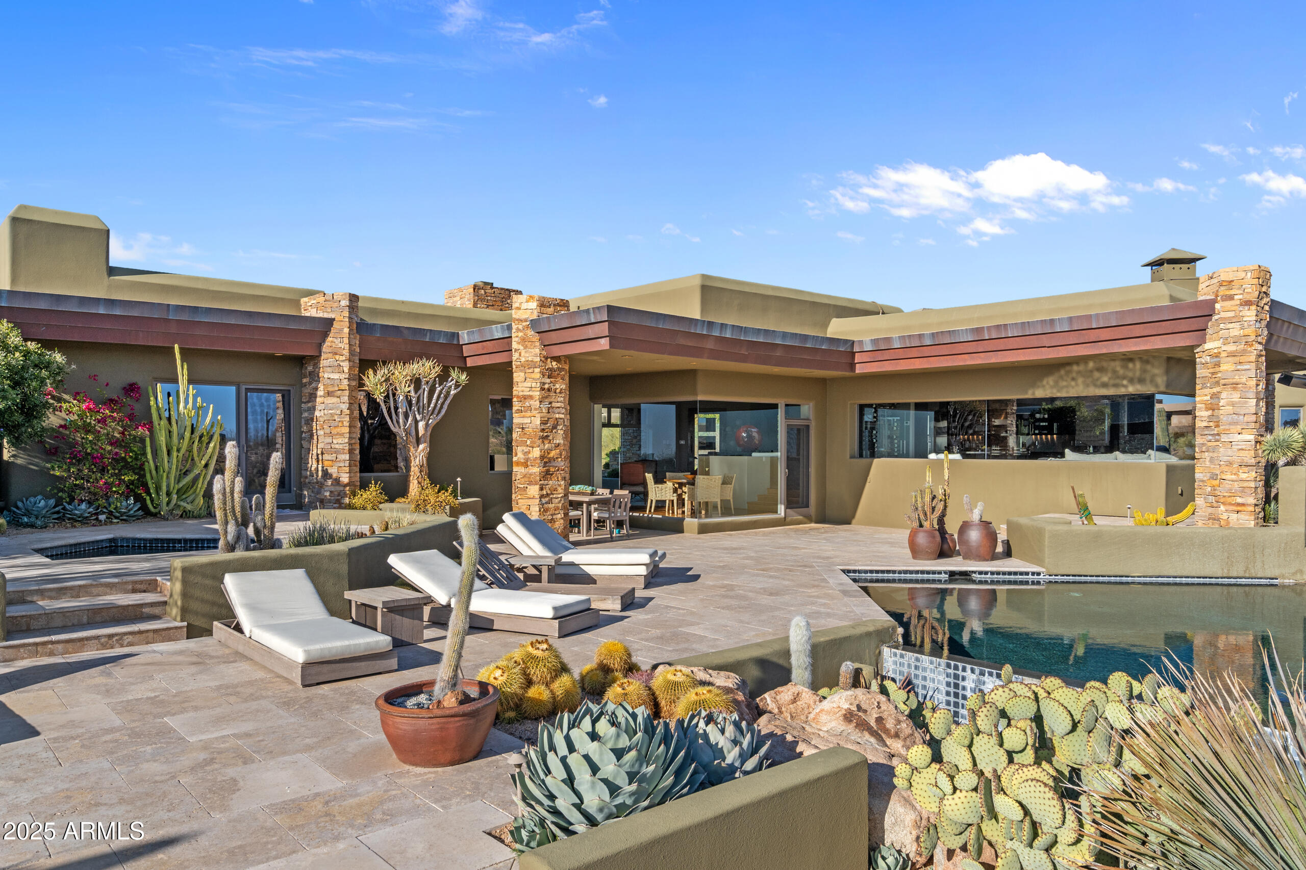 This gorgeous contemporary home is located in the exclusive gated community of Desert Mountain *FULL GOLF MEMBERSHIP AVAILABLE*, Minutes away from the Sonoran Clubhouse, this luxurious home offers a truly unparalleled living experience surrounded by golf courses and stunning mountain views of the city lights. This home features 3 ensuite bedrooms w/ 3 full baths, each offering ultimate privacy and comfort. Inside is a wonderful chef's kitchen w/ an island, double ovens and stainless steel fridge. On top of that, a spacious wine closet and bar! Enjoy the indoor/outdoor view of the serene atmosphere, ideal for relaxation or entertainment or step outside to the oversized back patio, where you'll find sparkling pools and spa, firepit, and an outdoor grill. Experience desert living at its finest - a perfect combination of luxury, comfort, and breathtaking views.