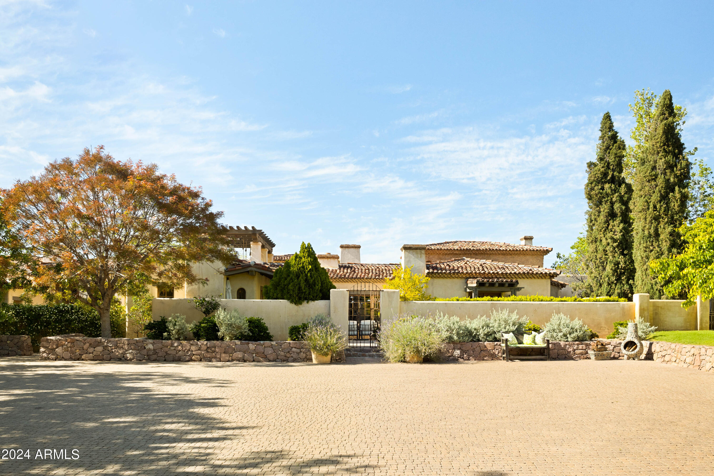 Step into a realm of refined French Mediterranean architectural grace! This extraordinary estate has undergone a tasteful rejuvenation in 2023, seamlessly blending antique European architectural
 elements for enduring allure. Spanning over 7300 square feet, this home boasts an array of amenities, including four bedrooms, five bathrooms, an office, billiards room, craft room, roof deck, and a three-car garage with ample guest parking. Explore the enchanting grounds, featuring four distinct courtyards, a vegetable and herb garden, eight fireplaces, a fire pit, private heated pool, and a wine cellar capable of housing up to 5000 bottles. Satisfy your culinary desires in the impeccably designed kitchen, outfitted with top-of-the-line Wolf appliances, such as a six-burner plus griddle, double oven range, steam oven, and Sub-Zero refrigerator and freezer. Elevate your mornings with the Miele in-wall espresso system and coffee cup warming drawer in the dedicated coffee station.Adjacent to the kitchen, the butler's pantry awaits to streamline your entertaining endeavors, conveniently located between the kitchen and dining area. Enjoy gatherings in the formal dining room, graced with elegant features, including a private courtyard view and seamless access to the wine cellar. Retreat to the sanctuary of the primary suite and revel in the breathtaking views of the lush grounds, private patio, and charming bench window nook. Indulge in a luxurious oasis within the primary bathroom, boasting a spacious walk-in shower, standalone tub, double vanities, and separate closets offering ample storage space. A spacious living room beckons for gatherings, while a billiards room offers leisure and enjoyment. Two inviting bedrooms, each with walk-in closets and scenic mountain views, complete the picture of comfort.
From the Venetian plaster walls to the rough-hewn ceiling beams, every corner of this home exudes timeless elegance. Adorned with a Redlands 5-tone clay tile roof featuring exquisite detail and custom European millwork throughout, the exterior radiates charm. Welcome to a residence where luxury meets artistry, and every moment is infused with sophistication and comfort.