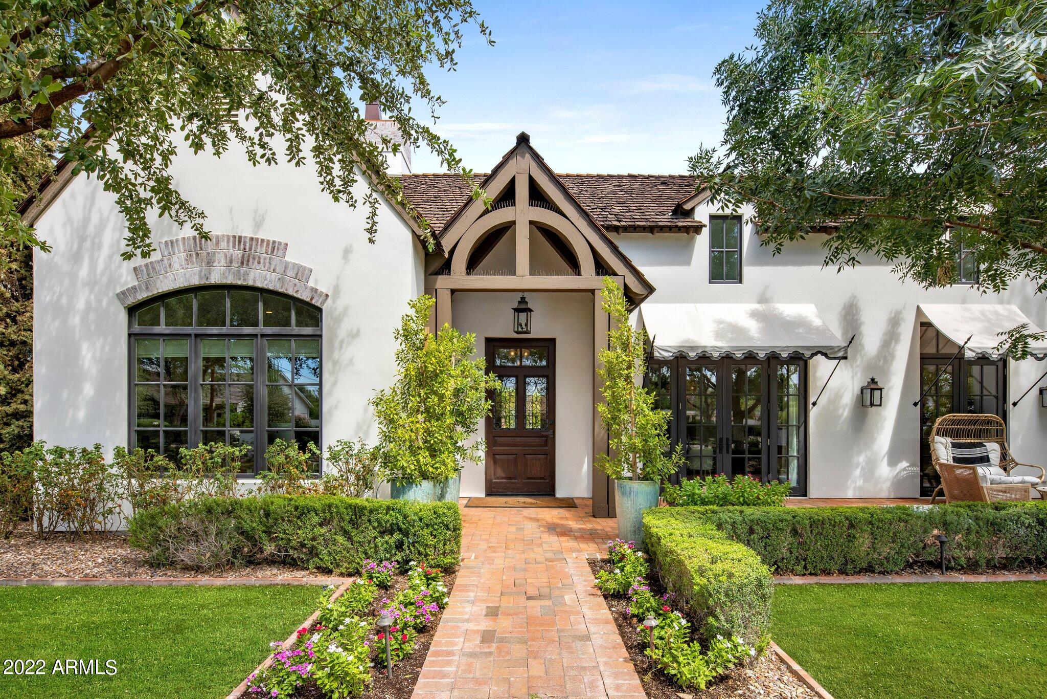 Timeless elegance in the heart of Arcadia. Remodeled in 2021, the French influence farmhouse has a modern twist while still maintaining the enchanting chemistry everywhere you look. The whimsical mature landscaping will make you forget you're in the desert. Entering the home you are met with a gorgeous grande foyer with wood floors, vaulted ceilings, wood beams, custom millwork and designer finishes. Oversized living and dining room that open to a lovely front patio. Open concept kitchen with top of the line appliances, built in breakfast nook and and adjacent full wet bar. Three generously sized guest suites, a secondary tv room and a bonus room perfect for a home gym or office await. The spacious primary suite boasts a cozy gas fireplace, arched hallway, soaking tub and a sleek walk in shower. The backyard features an outdoor dining room, swimming pool, large turf areas and mature landscaping framing the stunning views of Camelback Mountain.  Your dream home awaits!