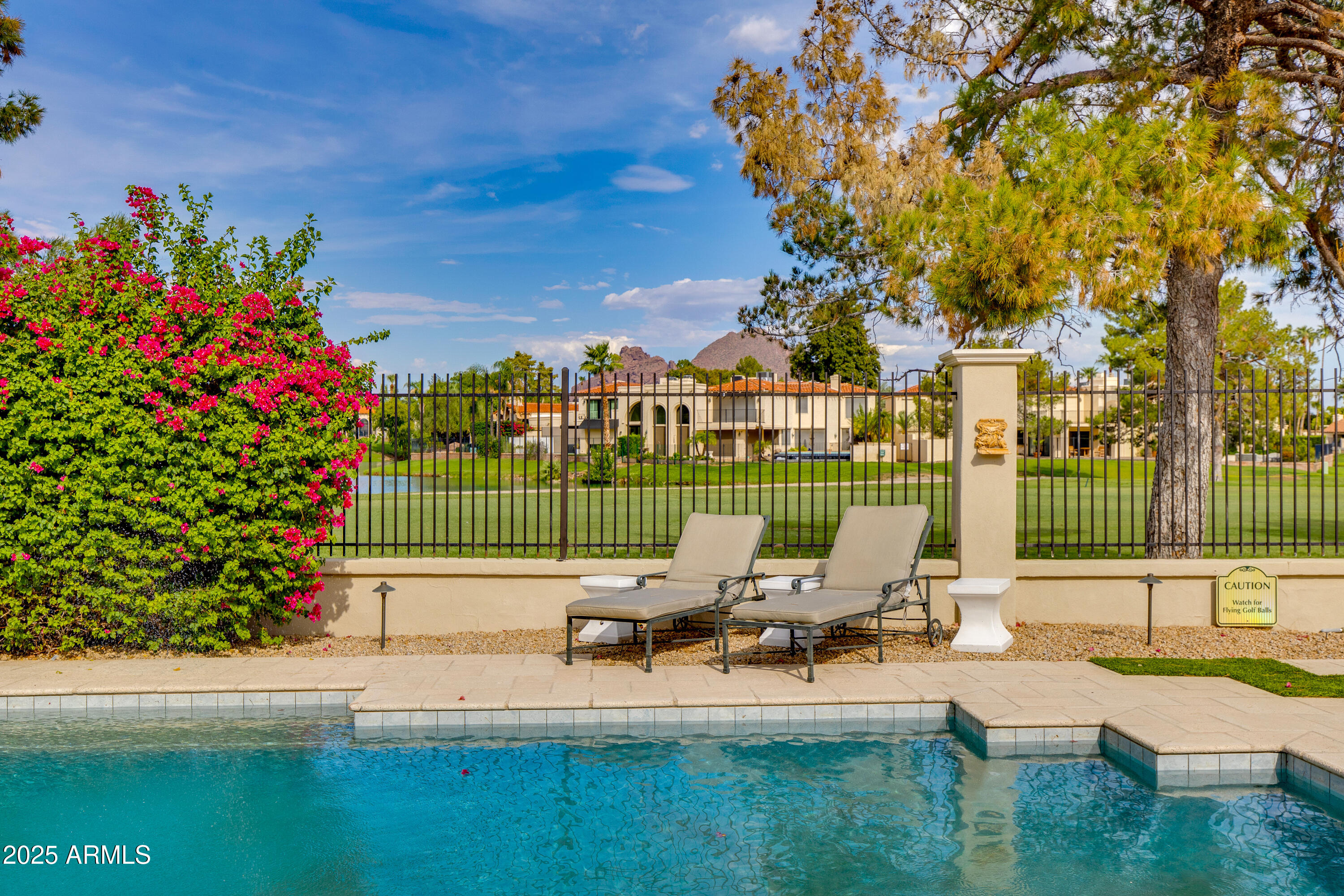 Welcome to 87 Biltmore Estate! Perfectly positioned at the end of a cul-de-sac, this single-level estate sits on an elevated golf course lot, offering views of Camelback Mountain and the prestigious Biltmore Links Golf Course. Step through custom iron doors into a foyer, where coffered ceilings, stone flooring, and abundant natural light fill the main living space. The kitchen is the true centerpiece, featuring a spacious island with seating, custom cabinetry, and stainless steel appliances. Just steps away, a built-in bar connects seamlessly to the living spaces, making entertaining effortless. This estate was designed for both work and play, offering a media room for movie nights, a private office or library for work, and a home gym. A private wing of the home is devoted to the primary suite complete with a fireplace and newly renovated spa-inspired bath featuring a spacious walk-in shower, dual vanities and custom closet. Guests will enjoy their own private wing with a separate entrance, ensuring comfort and privacy for all. Designed for the ultimate Arizona lifestyle, the backyard is an outdoor haven. Enjoy a pickleball court, a custom putting and chipping range, a fully equipped outdoor kitchen, a sparkling pool, and a luxurious spa. Rare, private, and impeccably appointed, 87 Biltmore Estate embodies the essence of Arizona Biltmore living.