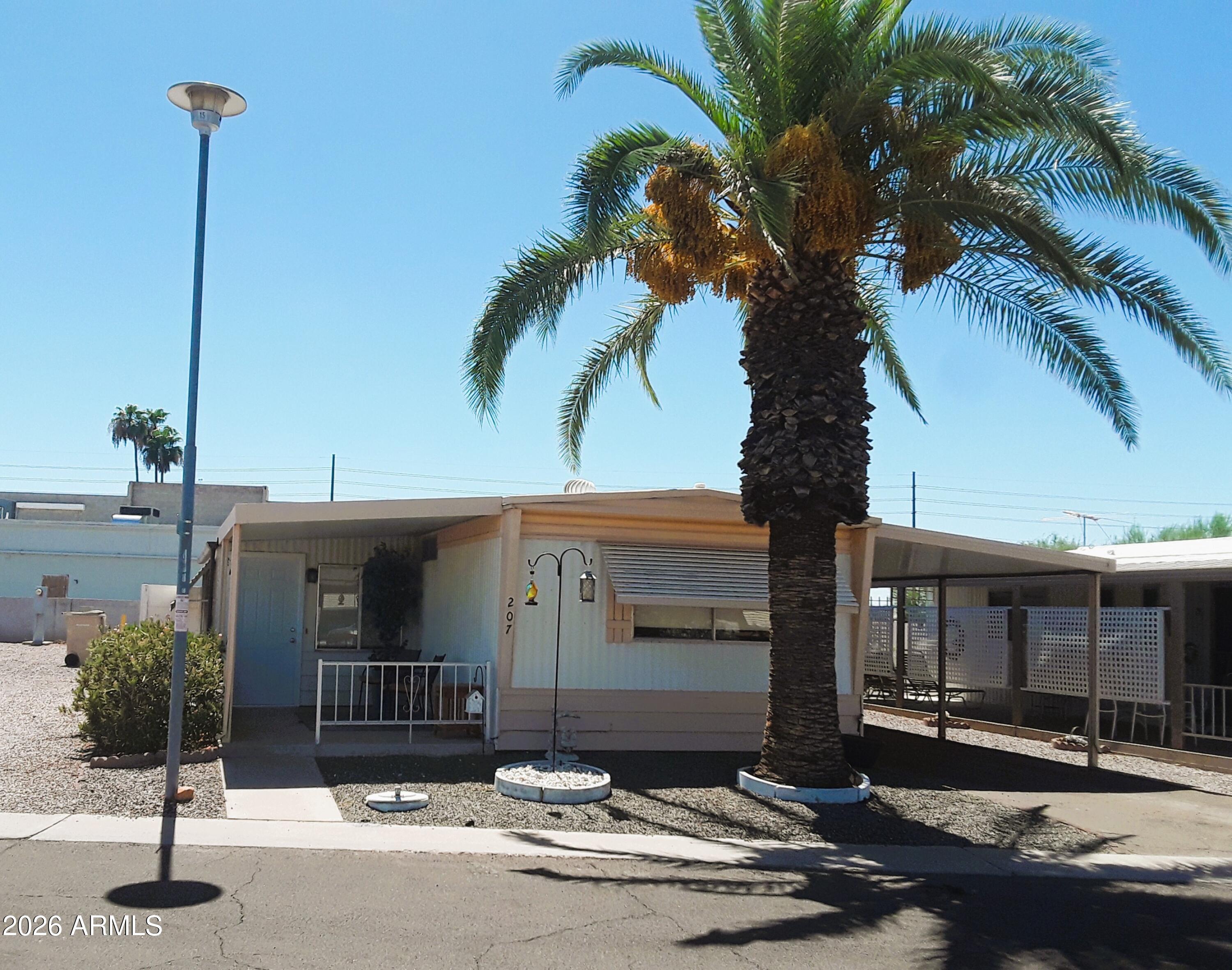 Comfortable 2 Bedroom, 2 Bath ground set home, split floor plan, covered patio,  private fenced yard.  Enclosed AZ room for recreation/hobbies. Inside laundry with full size W/D. 2 car carport, storage shed. All kitchen appliances include Frig, new gas stove top, oven, dishwasher, disposal.  New AC Unit [2026] H/W Heater [2021], Frig [2020] W/D [2021] Apollo Village is a 55+ age restricted community. Base lot rent is $891/mo.  All buyer's must obtain park approval for residency. Park amenities include heated community pool/spa, clubhouse, library, workout room plus weekly social activities including Bingo! Friendly neighbors!  Apollo Village borders Sun City and is near shopping, hospitals, clinics, restaurants, sports venues and casino.  Easy access to Hwy Loop 101.