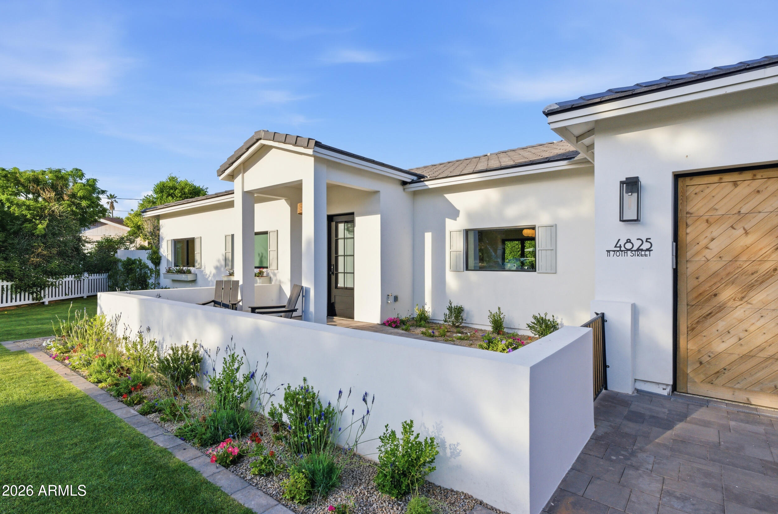 Discover the ultimate Scottsdale lifestyle in this modern luxury retreat, ideally located within walking distance to Fashion Square, Old Town Scottsdale & Camelback Mtn. Set on the largest corner lot on the block, the home's refined exterior features a white picket fence, paver driveway, lush front lawn, & custom oak garage door. Step inside to soaring ceilings, oak wood floors, & abundant natural light filling the open-concept great room. The designer kitchen is a true showstopper, centered around an oversized Taj Mahal waterfall-edge island, custom slim shaker cabinetry, gold hardware, farmhouse sink & designer appliances - perfect for entertaining or daily life. The serene primary suite offers a spa-like bath, expansive walk-through closet & sliding panoramic glass doors that seamlessly blend indoor and outdoor living. The backyard is a private paradise with a 40-ft pool, massive limestone patio & pool decking, built-in BBQ & 25+ ft "Hollywood" ficus hedges, & views of Camelback Mountain. This Scottsdale corner-lot jewel is new construction & ready for your luxury lifestyle.