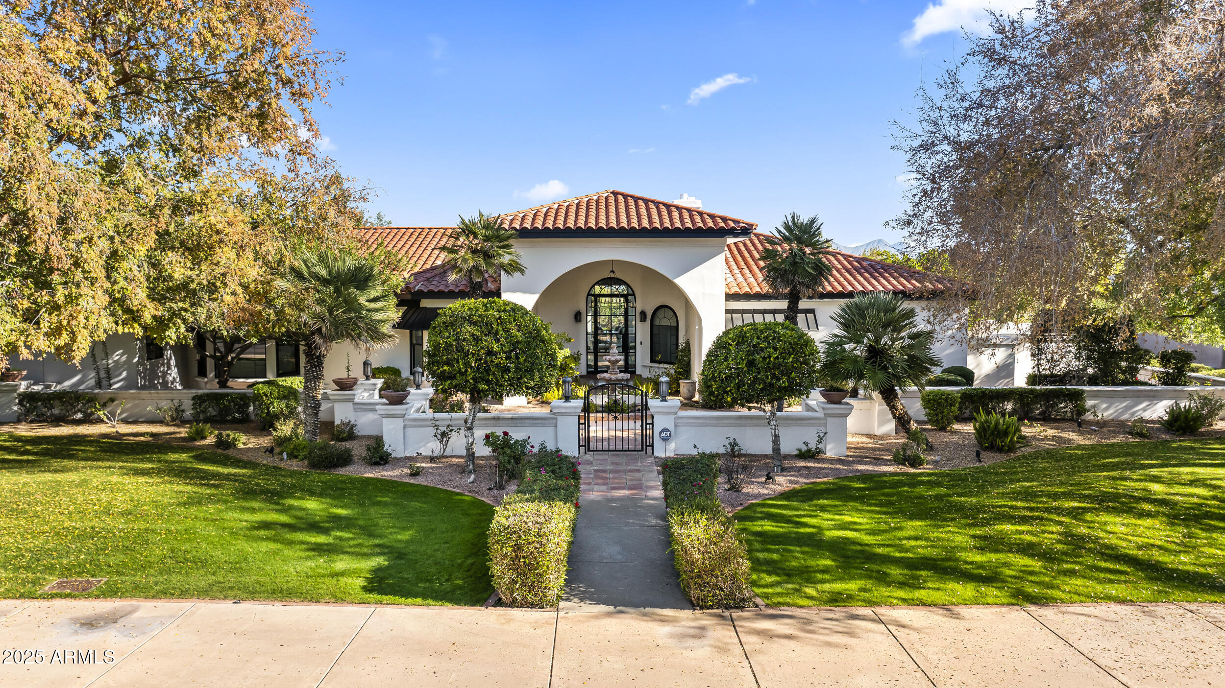 Santa Barbara presence. Completely REMODELED throughout. Porcelain tile floors create continuity. Palladian windows bring in soft light. Fairway views remain open. Ambiente Golf Course ahead. McDowell Mountains beyond. Courtyard arrival feels intentional. Single-level living flows easily. Three en suite bedrooms offer privacy. A wood paneled office adds warmth. The gourmet kitchen is refined. Quartzite stone counters . Two dishwashers. Walk-in pantry. It opens to a beamed family room with one of three fireplaces. The primary suite feels dramatic. His and hers closets. Rear patios stay private. Mature landscaping surrounds the home. Designer finishes throughout. High-end. Timeless.