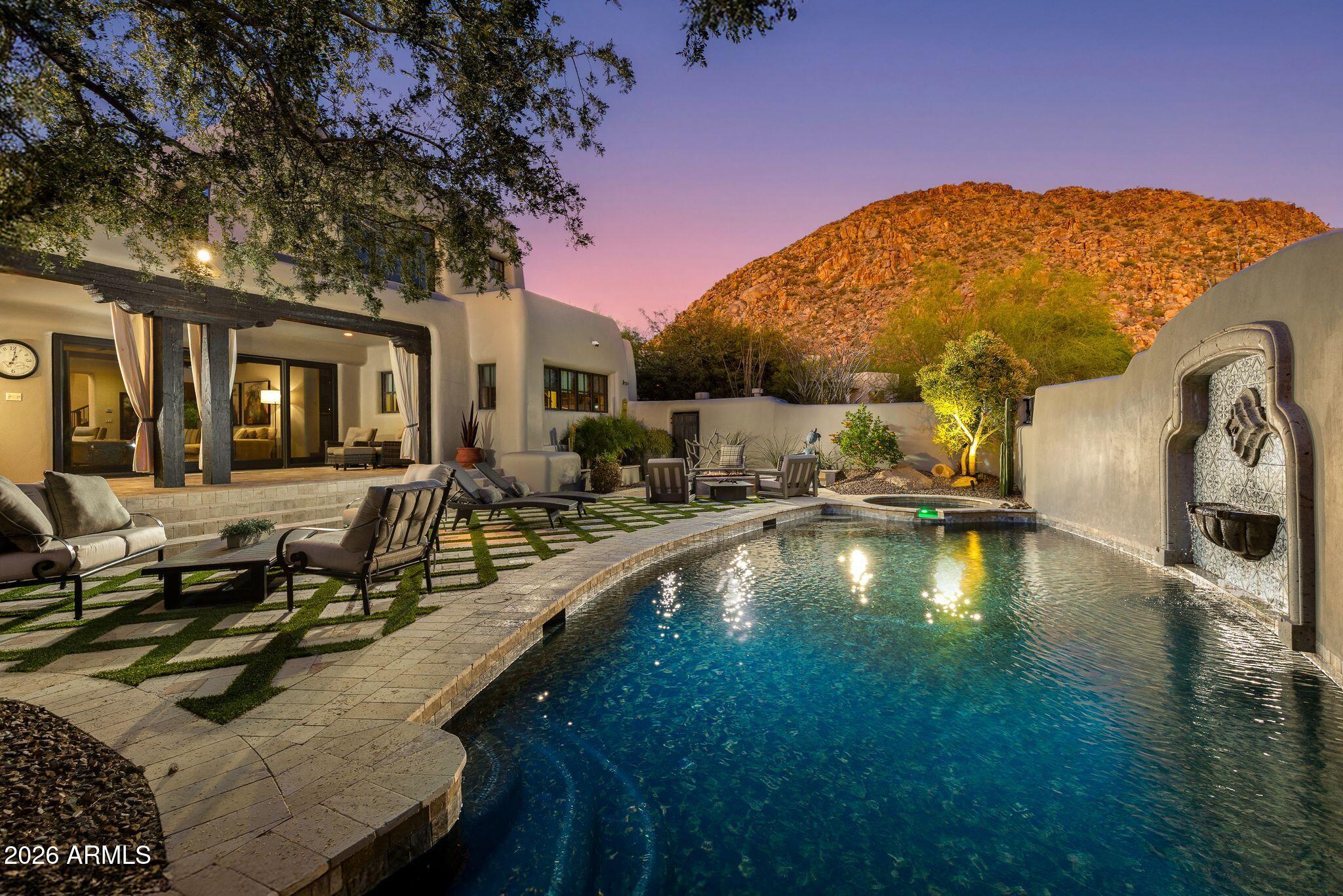 This stunning Spanish Modern residence in the prestigious guard gated community of Desert Highlands offers a rare combination of character, craftsmanship, and enduring quality. Situated on Quiet cul-de-sac and circle driveway. Candelaria Designed home for the discerning buyer who values thoughtful construction and meticulous care, this home showcases custom cabinetry, travertine and granite surfaces, reclaimed wood beams and flooring, and artisan ironwork--materials selected for their beauty, longevity, and integrity.
Completely remodeled and impeccably maintained, the home features a luxurious primary retreat with steam shower, fireplace, and private washer/dryer. Two spacious ensuite bedrooms provide comfort and privacy, while a detached two room guest house - complete with living room, kitchen, bedroom, and full bath--offers an ideal setting for extended stays or multigenerational living.
The sunlit great room overlooks the serene backyard, and the gourmet kitchen is equipped with top tier appliances including a steam oven and wine refrigerator. A charming breakfast room opens to a cozy patio with built in Wolf BBQ and water feature. Formal dining and multiple inviting gathering spaces elevate both everyday living and elegant entertaining.
Trademark Landscape designed Outdoor living is exceptional, with expansive covered patios, a dedicated outdoor living room, heated pool and spa, and picturesque mountain views. Every space reflects pride of ownership and a commitment to quality.
Residents of Desert Highlands enjoy world class amenities, including the Jack Nicklaus Signature championship golf course, a unique 18 hole putting course, award winning clubhouse with "Jack's Backyard," a newly remodeled state of the art fitness center, the Highlands Racquet Club, and seven additional satellite courts throughout the community.
A home of this caliber appeals to the buyer who values substance over flash, craftsmanship over trend, and a lifestyle rooted in comfort, privacy, and enduring elegance.