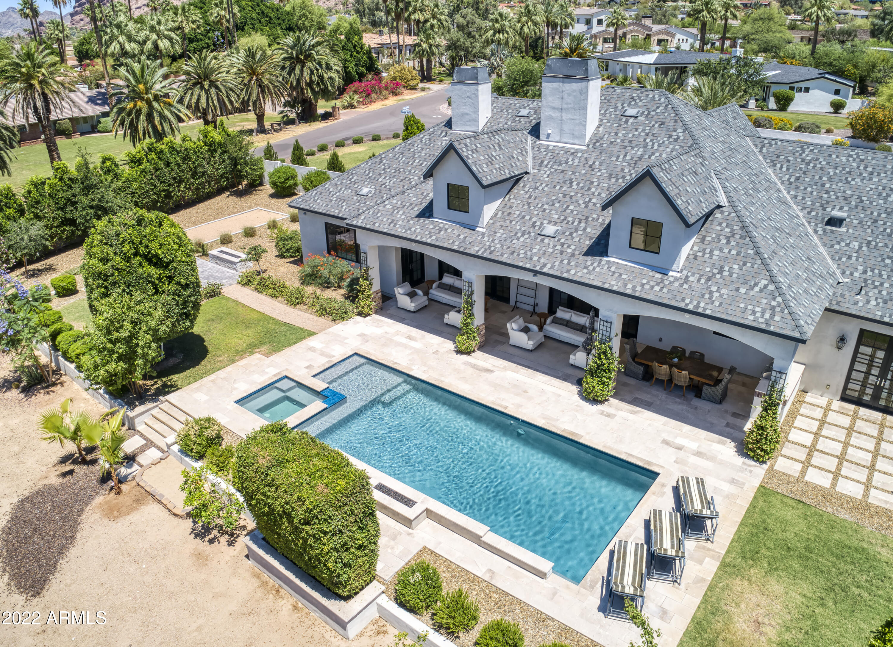 This exquisite home is perfect for a large family or the couple who loves to entertain. With soaring ceilings and grand spaces, it is luxurious and elegant, yet warm and charming. The gorgeous courtyard leads to a gracious foyer and into a home filled with magnificent rooms with views of spectacular Camelback Mountain pouring in. The island kitchen is fabulous and flows into the comfortable great room, the Living Room is formal, yet serene, the Dining Room is just exquisite, and all the bedrooms and bathrooms are lovely, including a fabulous Master Retreat. The high-quality finishes are complemented by exceptional designer furnishings, and this home is available turnkey should that be desired. Natural light spills in the extra-large doors and opens to the beautiful backyard oasis, complete with pool, hot tub, fire and water features, separate firepit area and huge covered patio, great for entertaining. You will be impressed at every turn at the thoughtful design, luxury finishes, and perfect execution that has gone into this very special home.